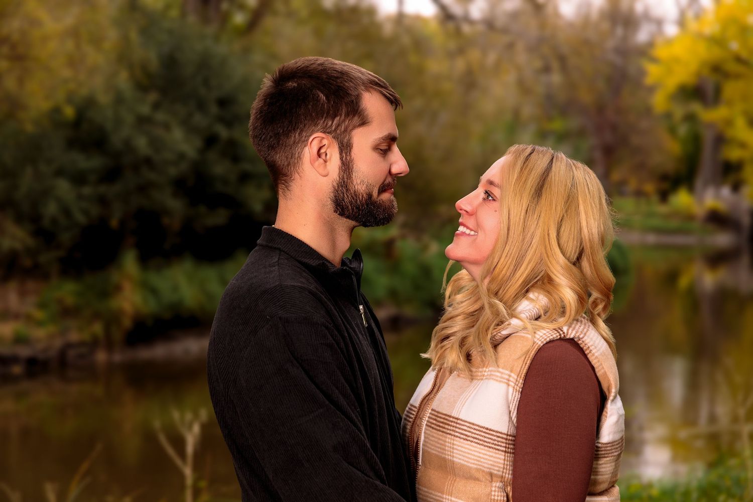 Intimate couple portraits captured in a scenic fall setting with water backdrop.