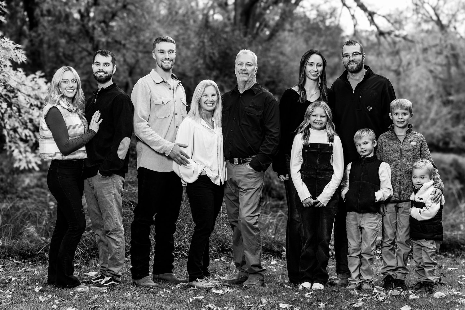 A series of black and white family portraits taken outdoors showing different poses and groupings.