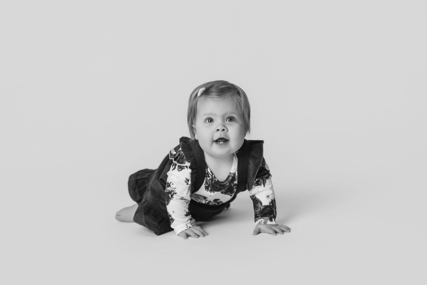 Baby crawling sequence captured in monochrome studio setting.