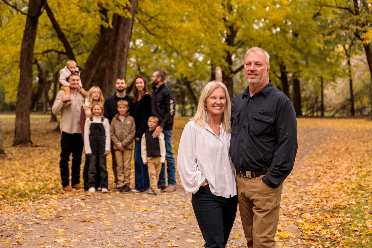 A group photo taken on a path surrounded by golden autumn trees in a park.