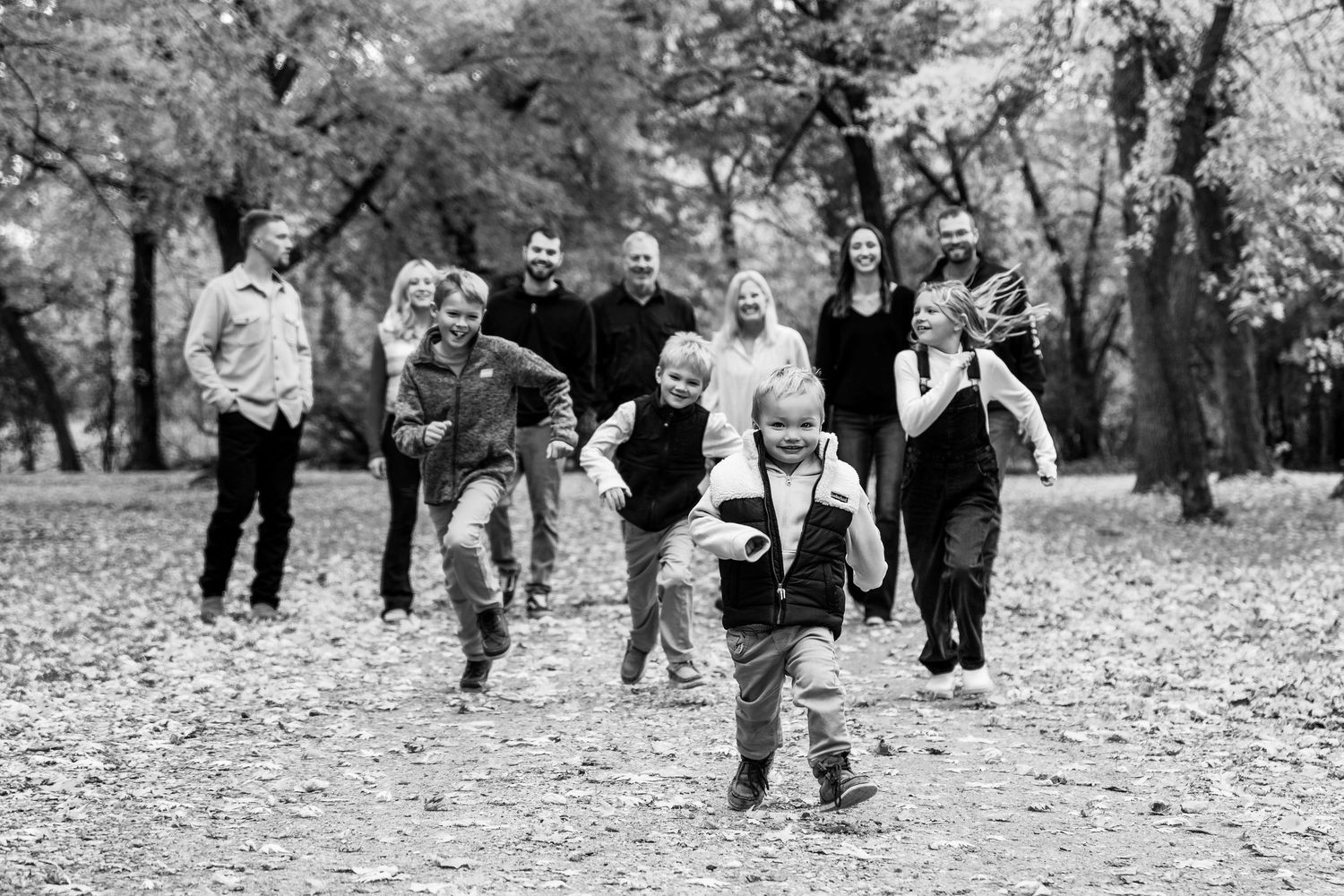 Black and white candid shots of a group walking through fallen leaves in an outdoor setting.