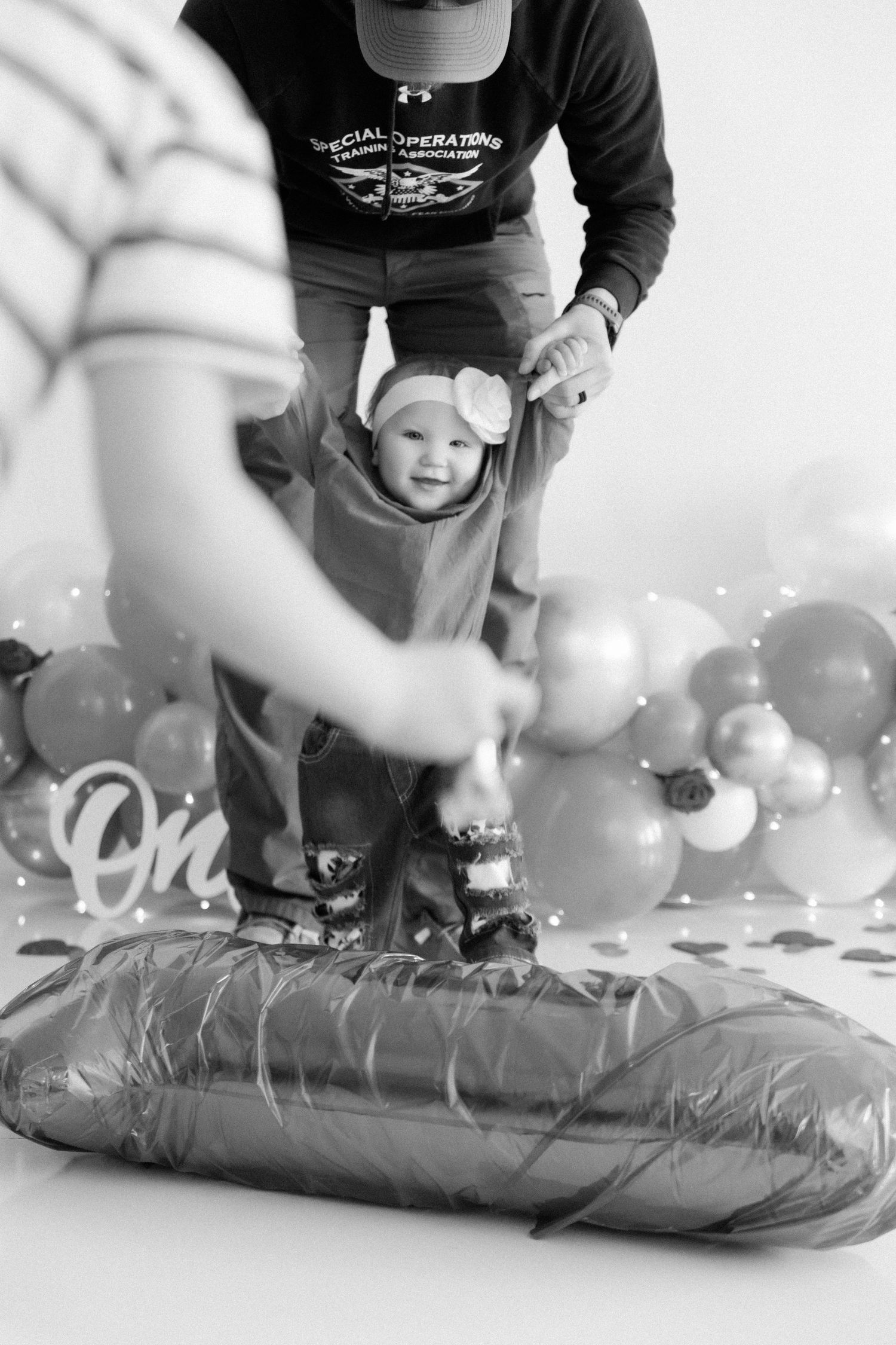 Black and white images showing behind-the-scenes setup of a balloon-themed photo session.