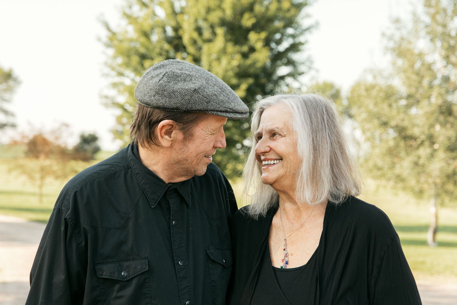 Elderly couple enjoying a romantic moment together in a park during autumn.