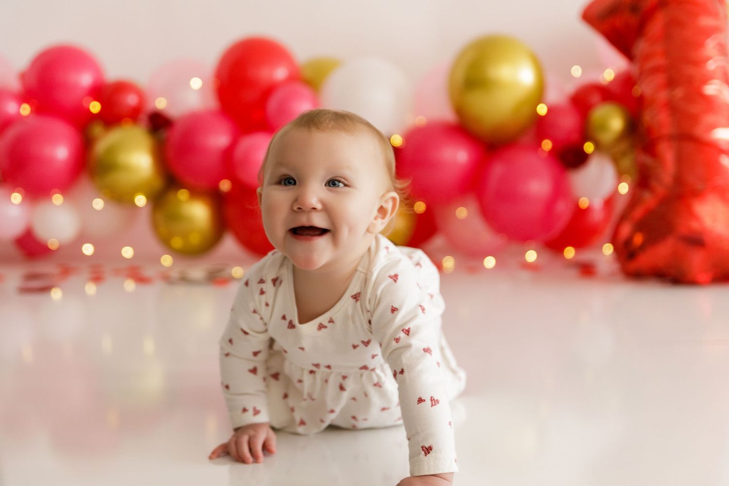 Festive balloon garland in pink, red and gold creates a cheerful party backdrop.