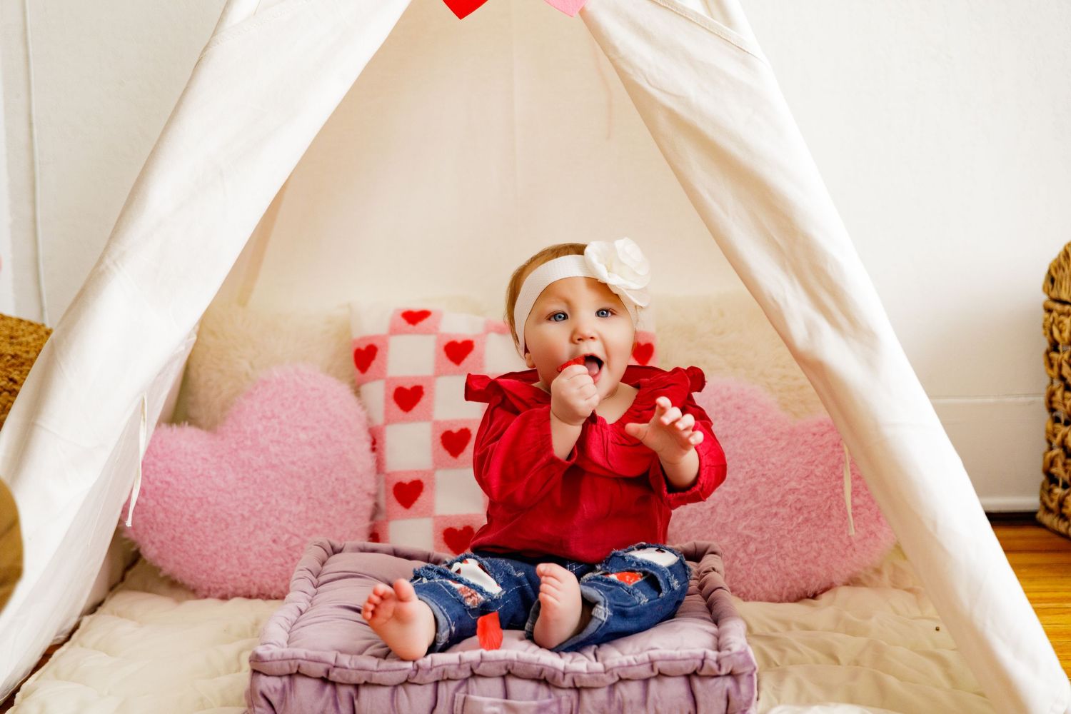 White tent decorated with red hearts and pink accents for a Valentine's day photo session.