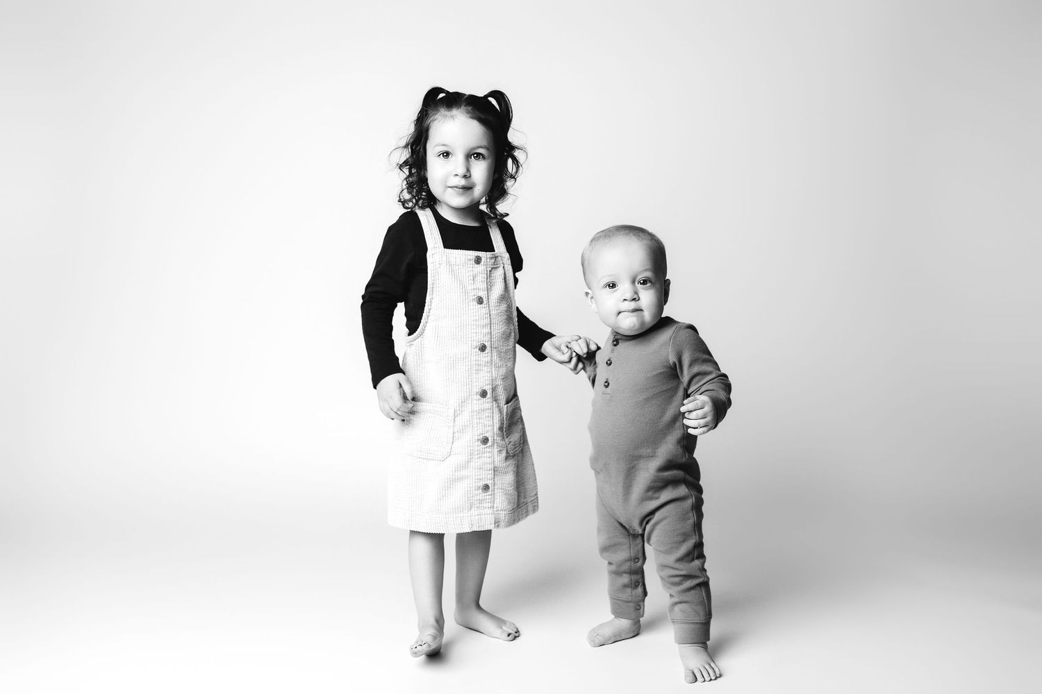 A series of black and white photos showing a baby's progression from sitting to standing and walking.