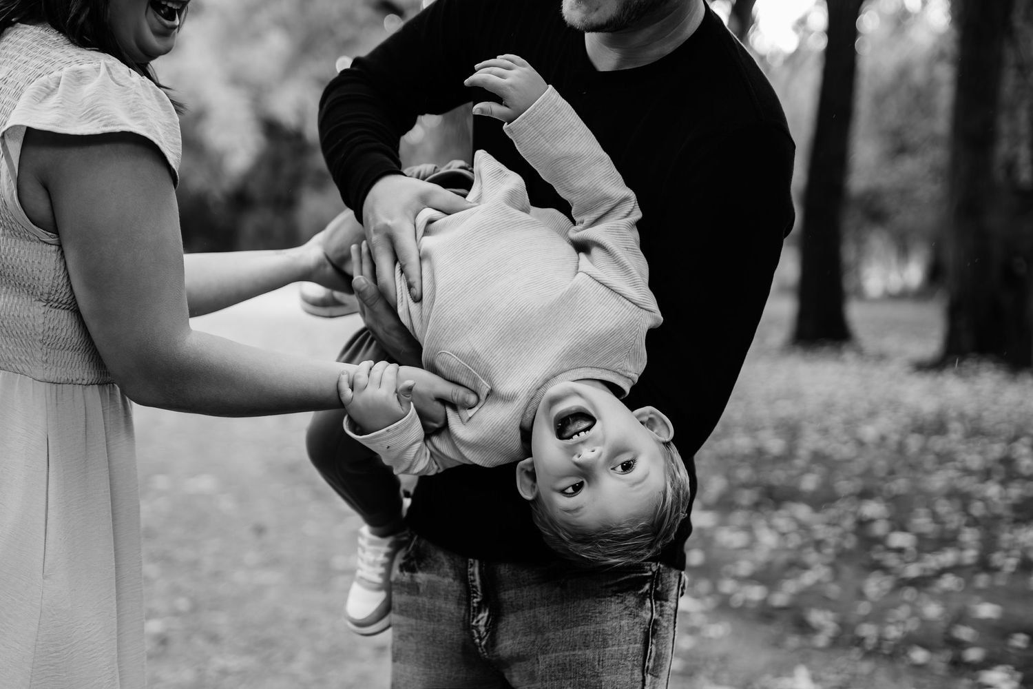 Playful black and white candid moments captured during an outdoor family photoshoot.