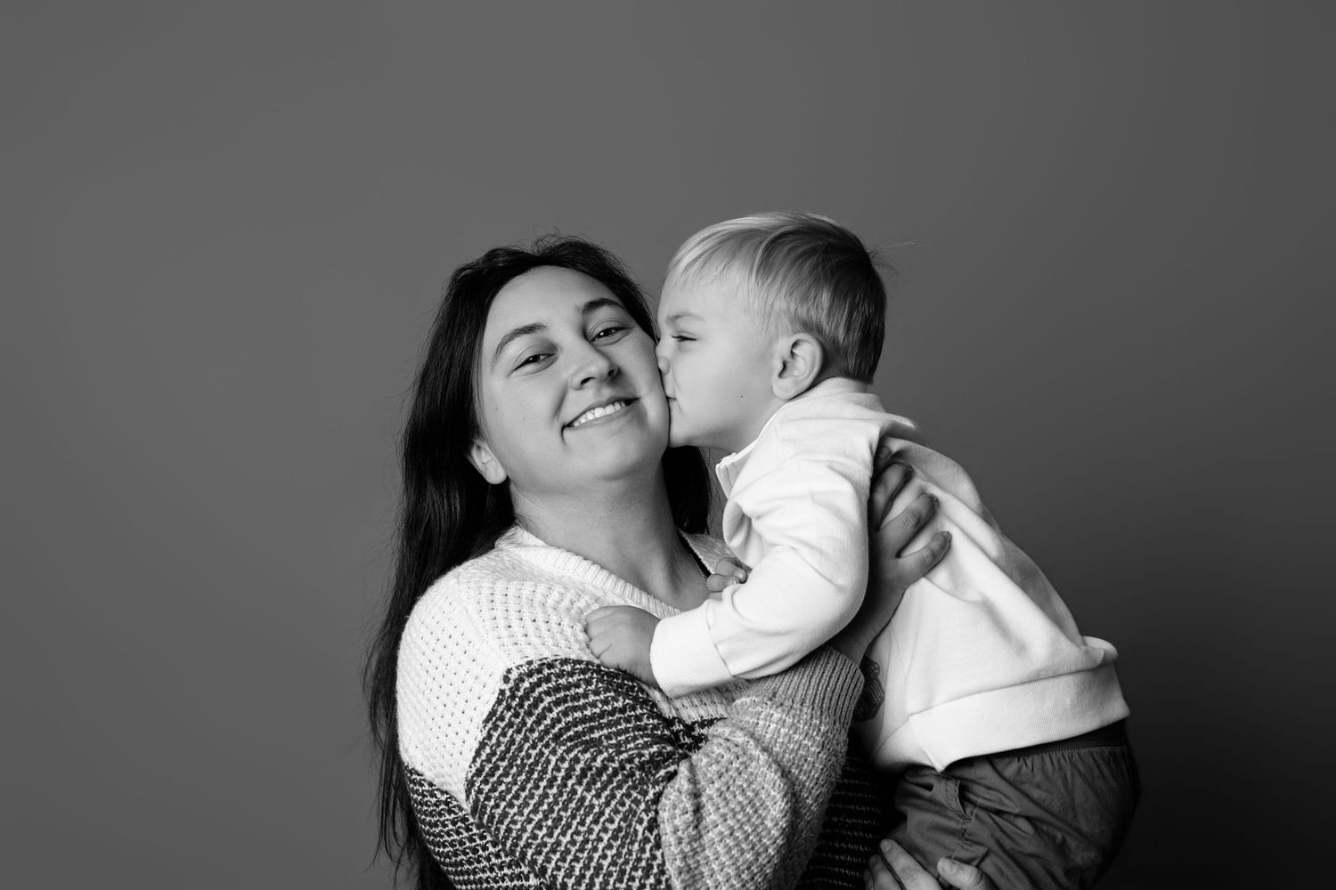 A series of tender black and white photographs showing loving embraces between parent and child.