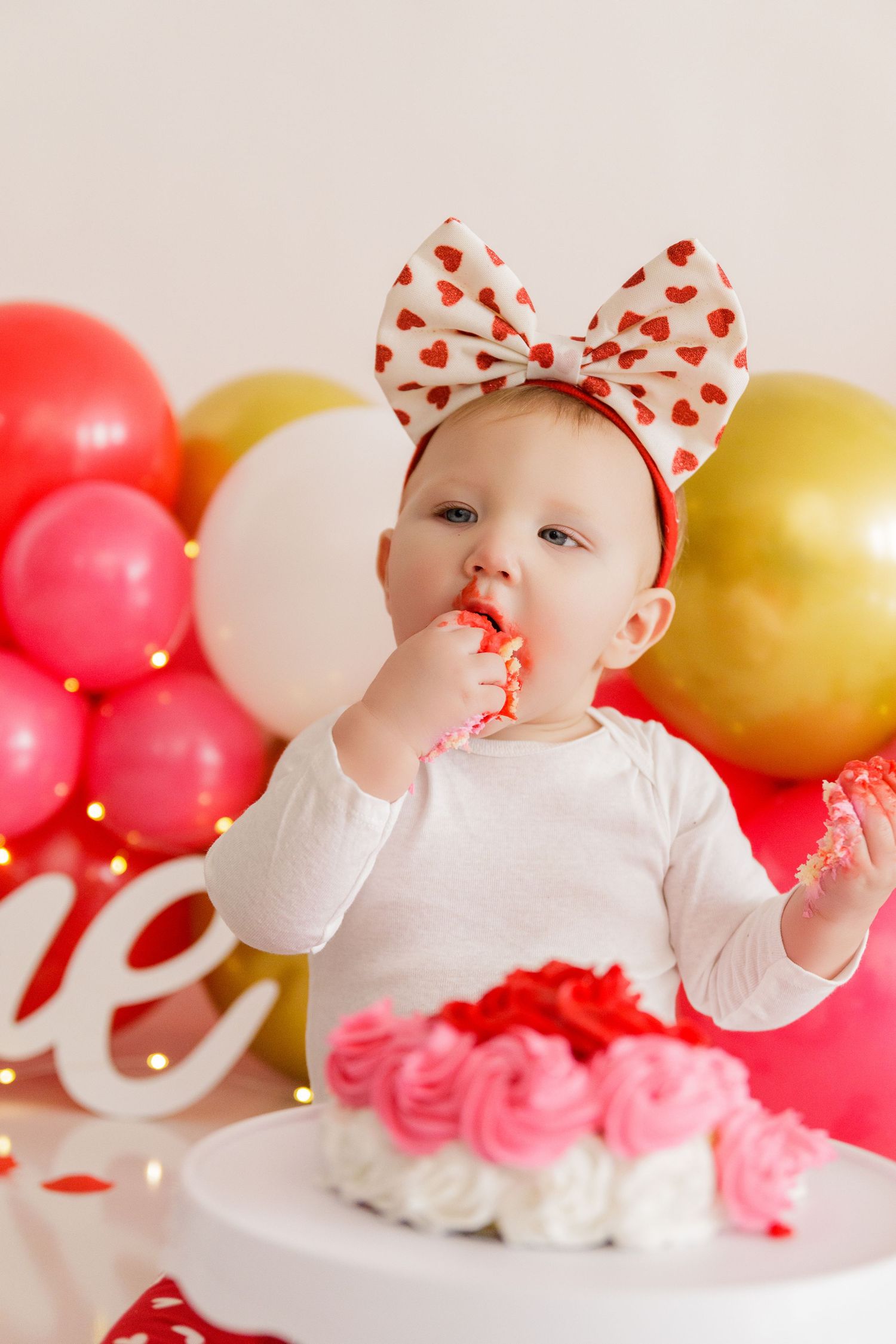 Valentine's themed photo with red and gold balloons and heart decorations.