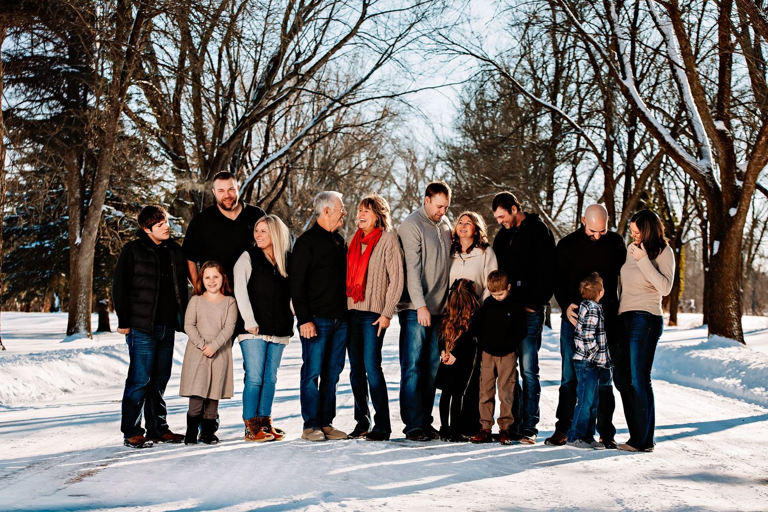 Group of people walking together in a snowy winter park landscape.