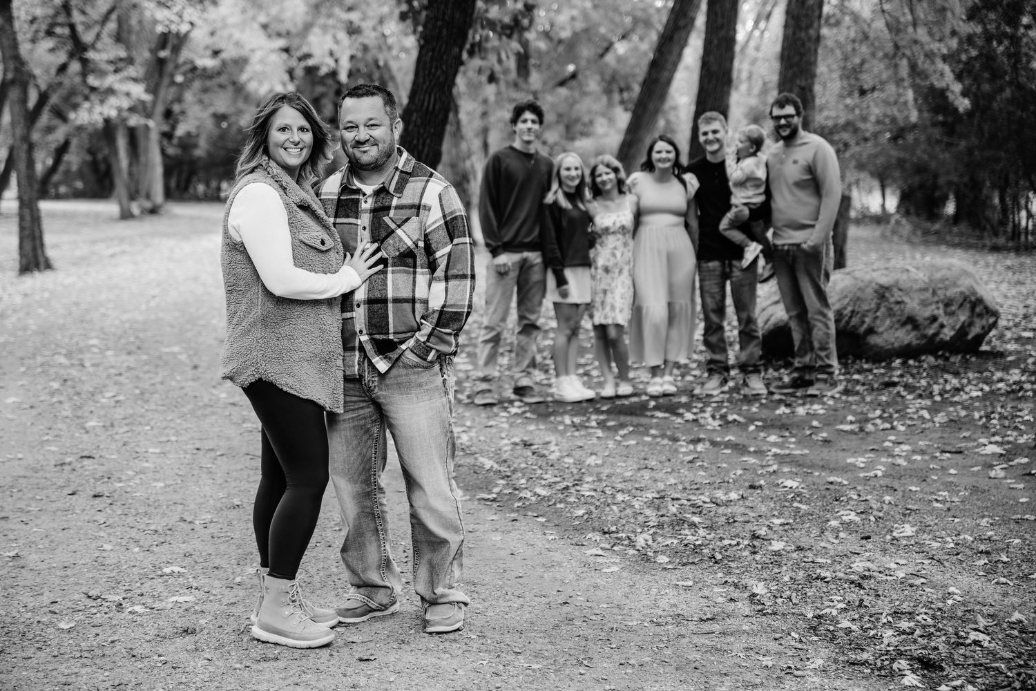 A group of people gather together outdoors during a fall photo session.
