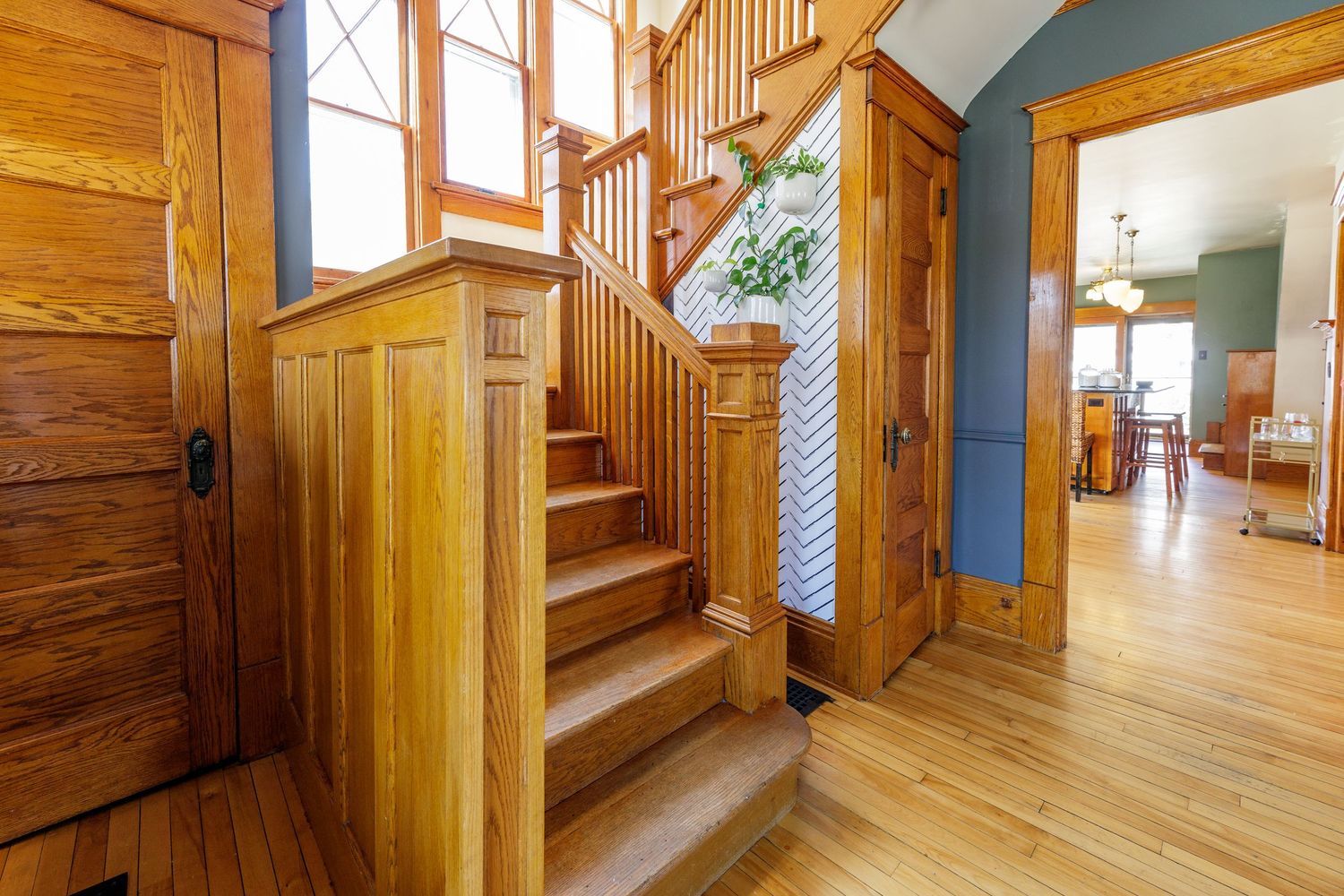 Elegant wooden staircase with oak banister and hardwood floors in a classic home entryway.