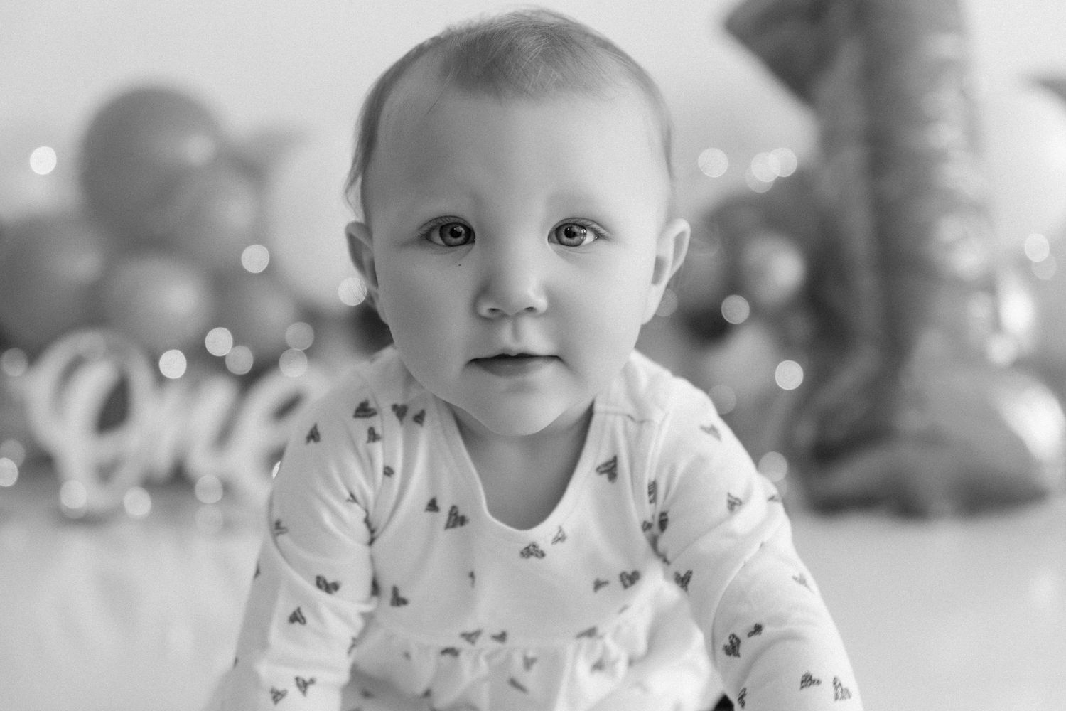 Black and white portrait style photo with soft lighting and bokeh effects in the background.