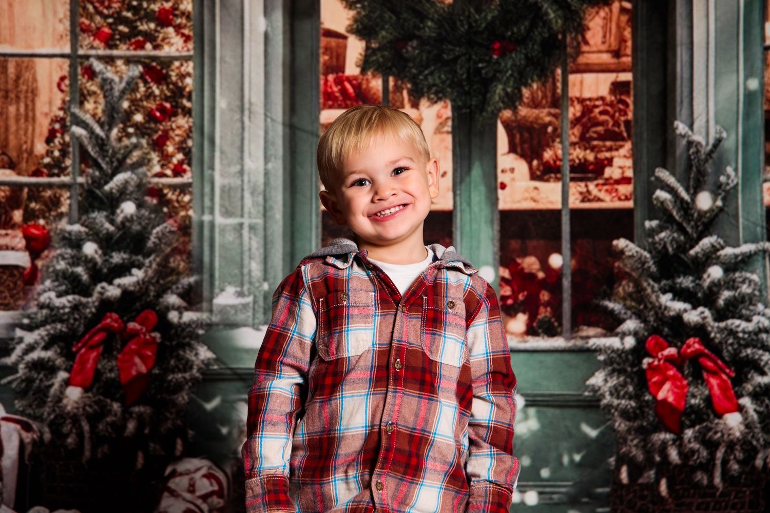 Christmas themed portrait session with decorated trees and red holiday accents.