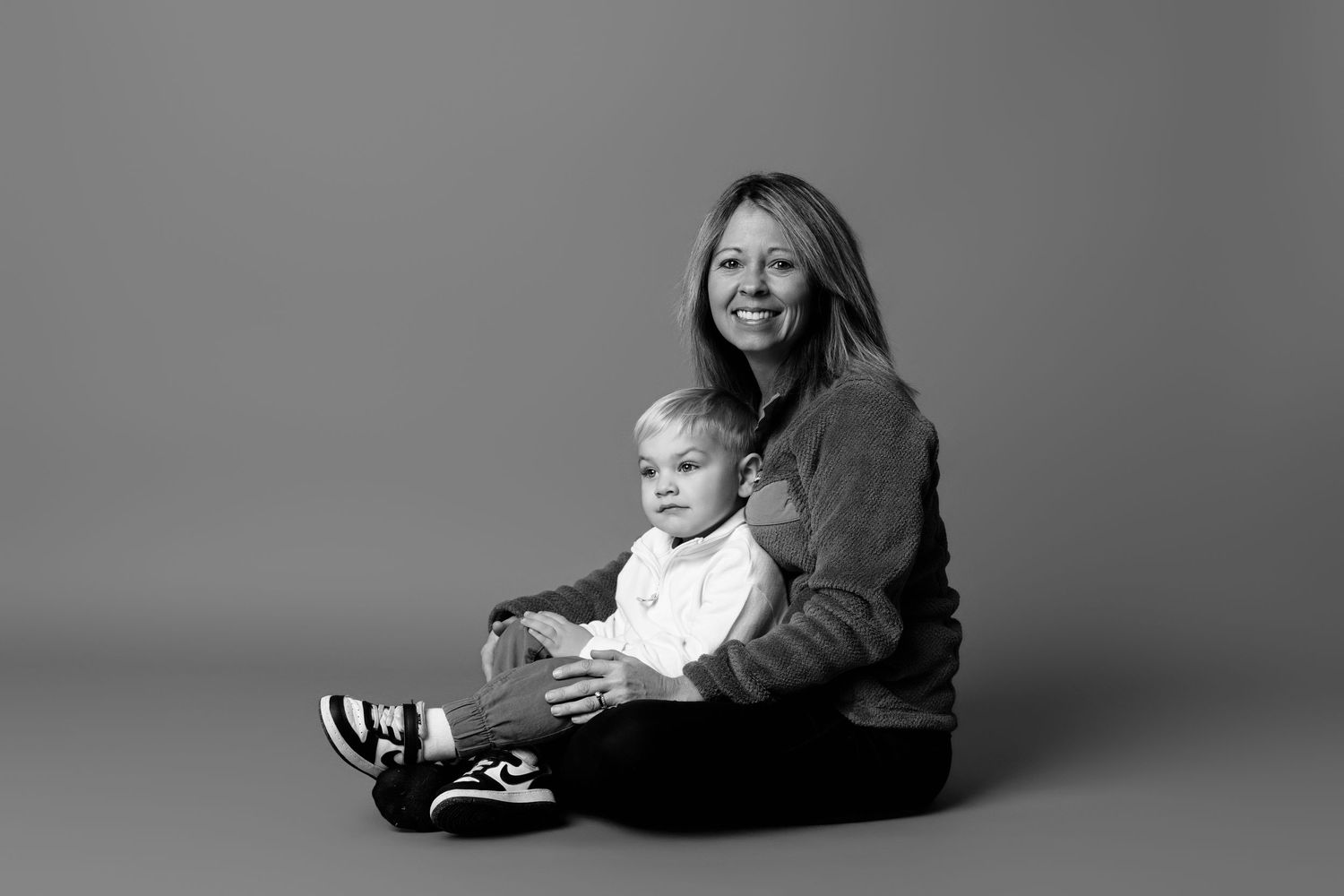 Black and white studio portraits showing joyful expressions against a simple backdrop.