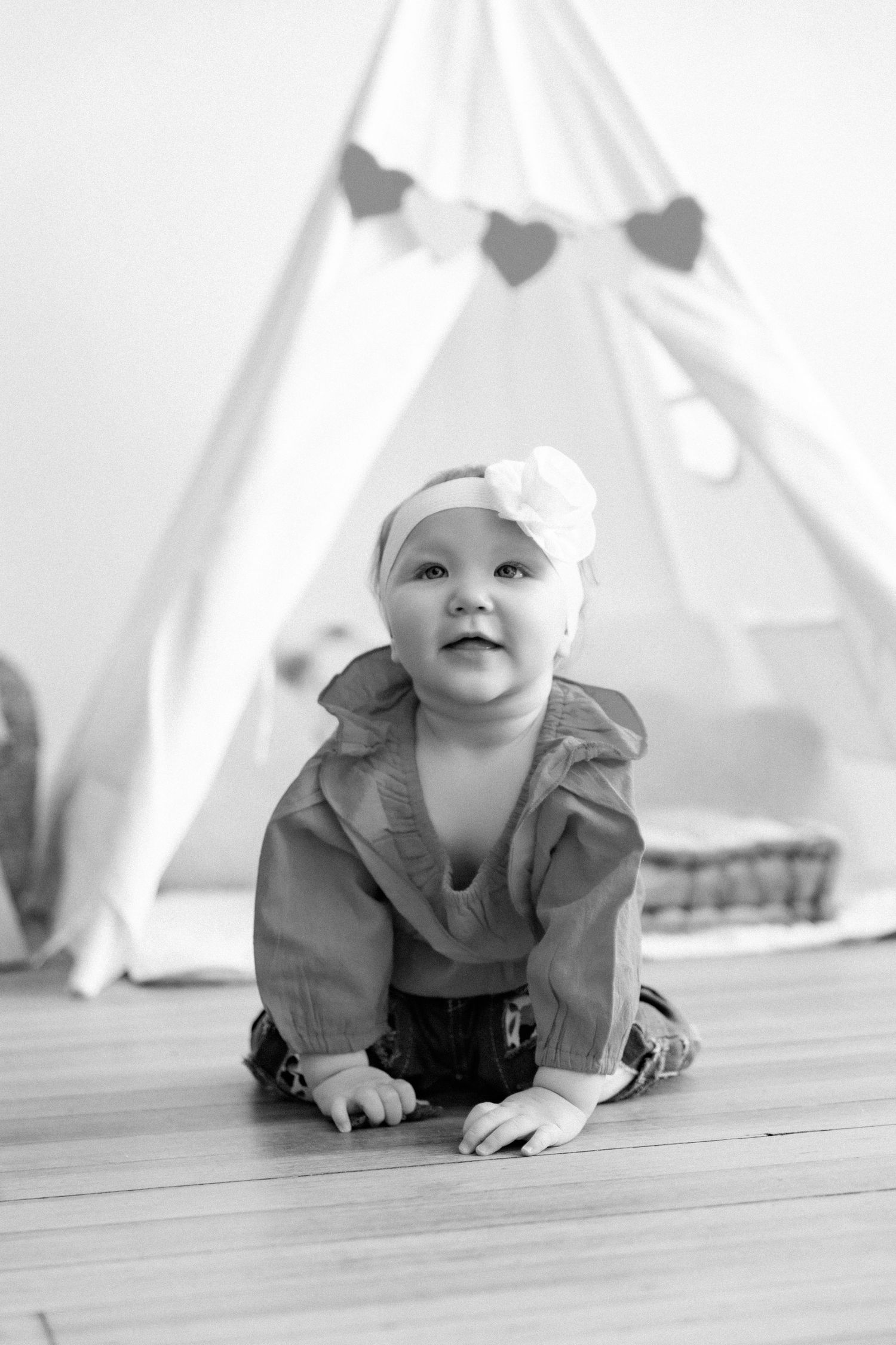 Black and white images of crawling movement under a white teepee tent.