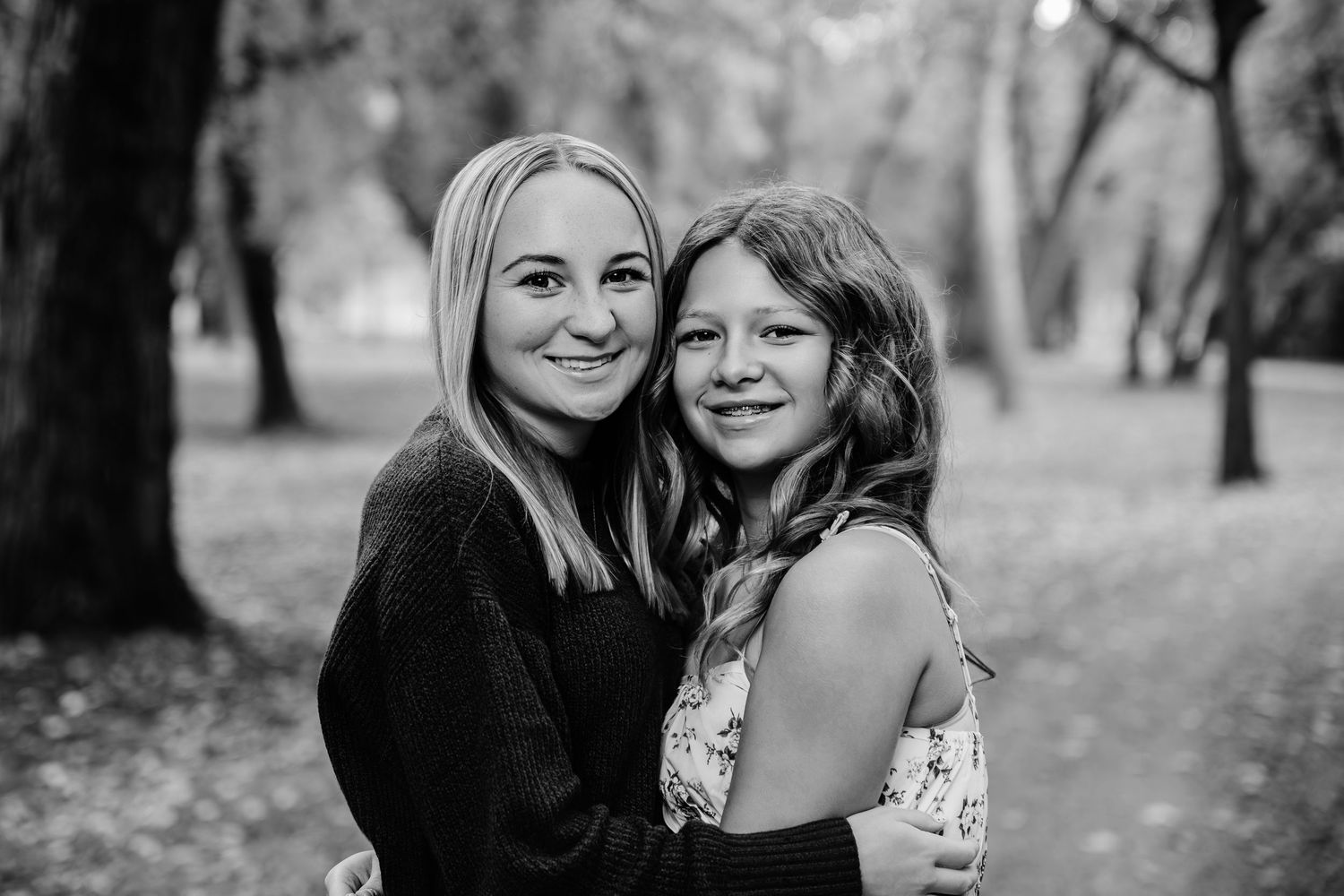 Natural family portrait session in black and white with park backdrop.