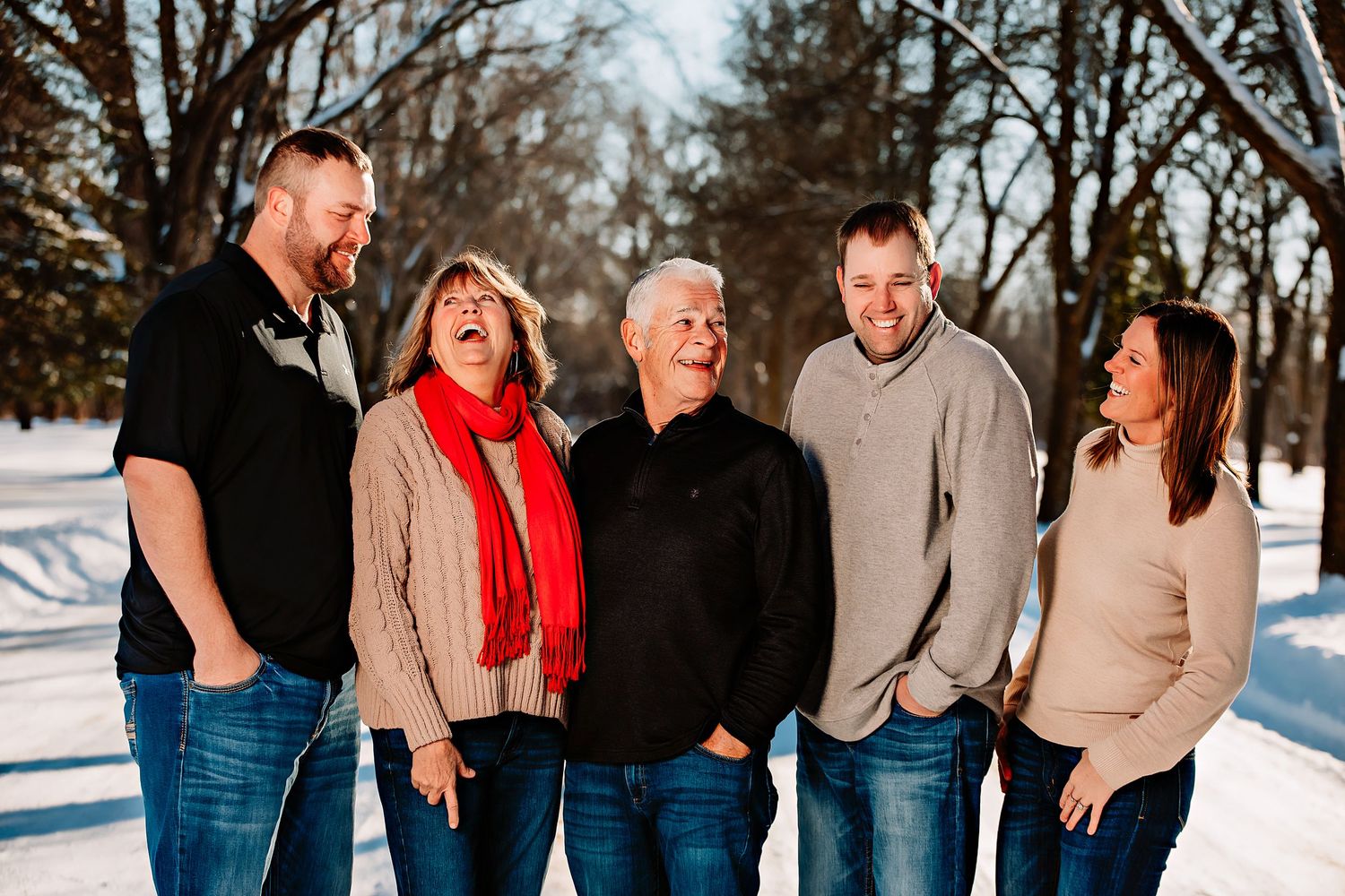 Group sharing laughs and candid moments while standing together in the snow.