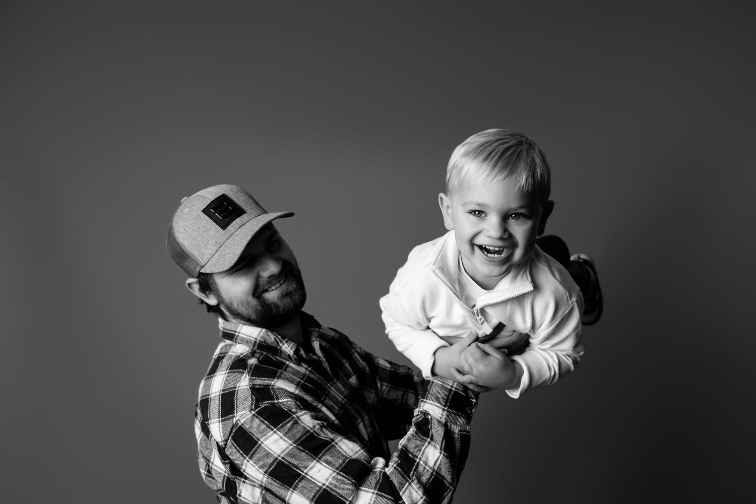 Dynamic black and white studio portraits capturing playful moments and laughter.