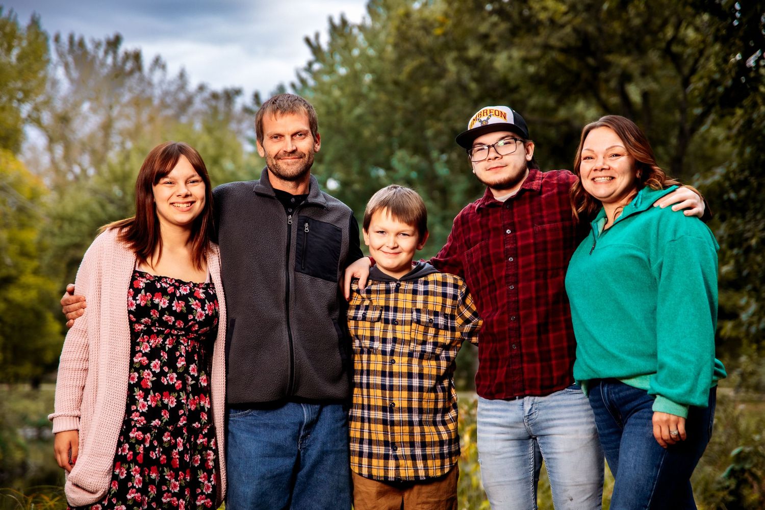 A collage of outdoor autumn family portraits taken in a natural setting surrounded by trees and fall foliage in Western Minnesota.