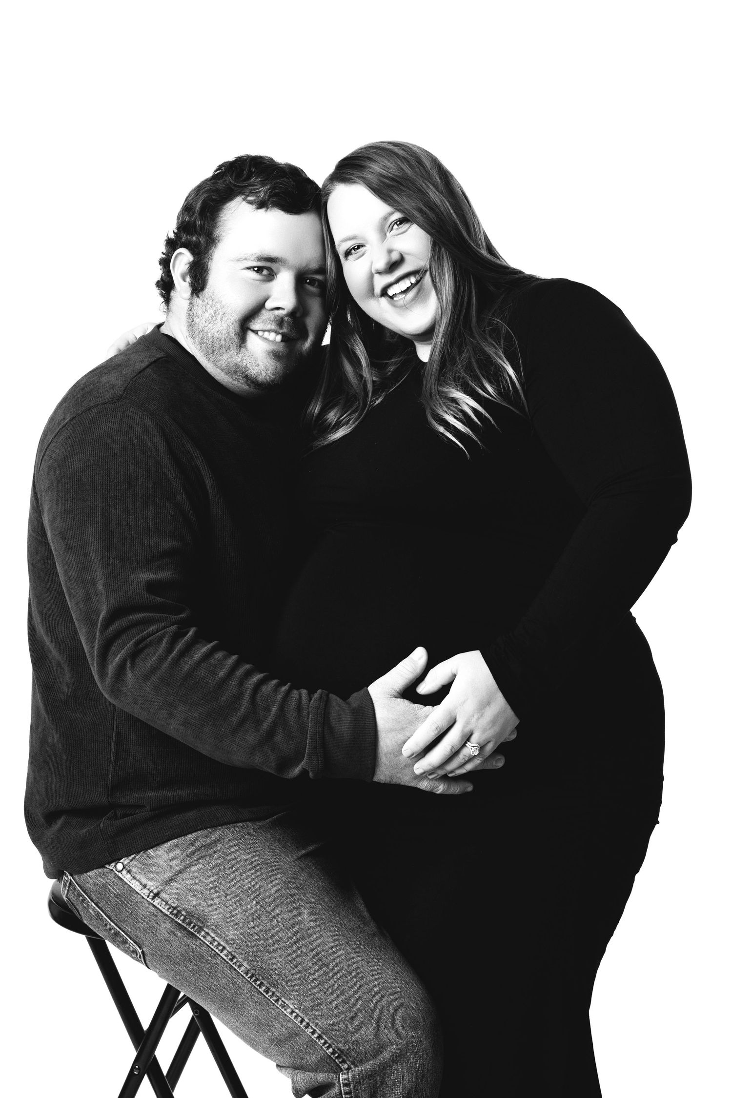 A series of black and white portraits showing a couple laughing and embracing while sitting on chairs.