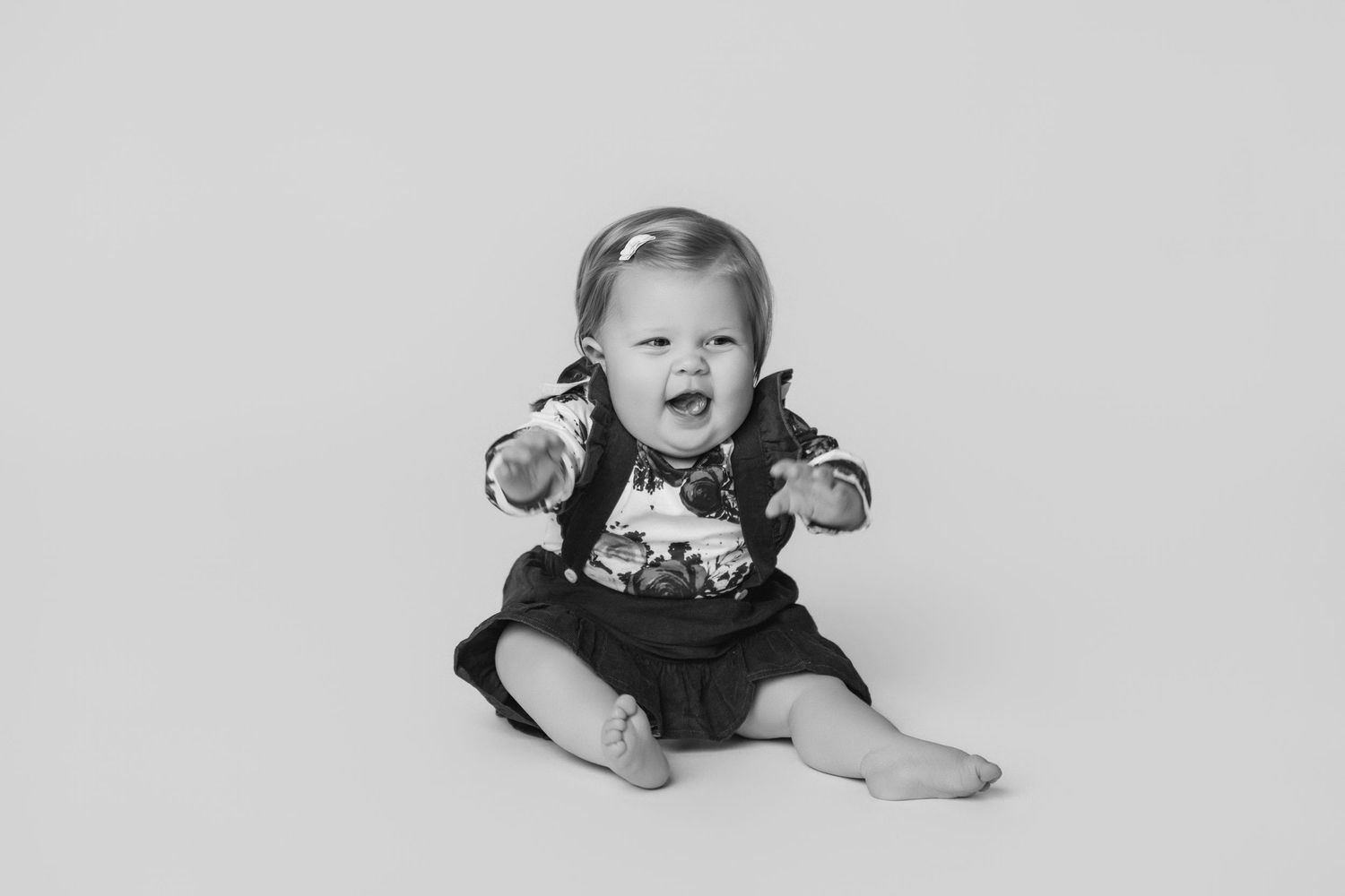 Baby in dark dress crawling and exploring studio setting.