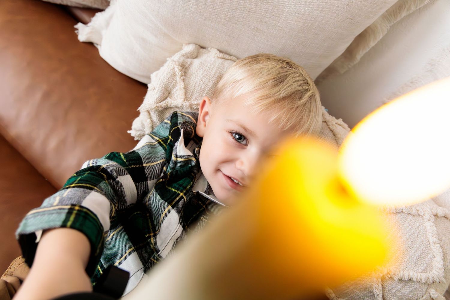 Close-up holiday portraits showing genuine expressions with Christmas lights in background.