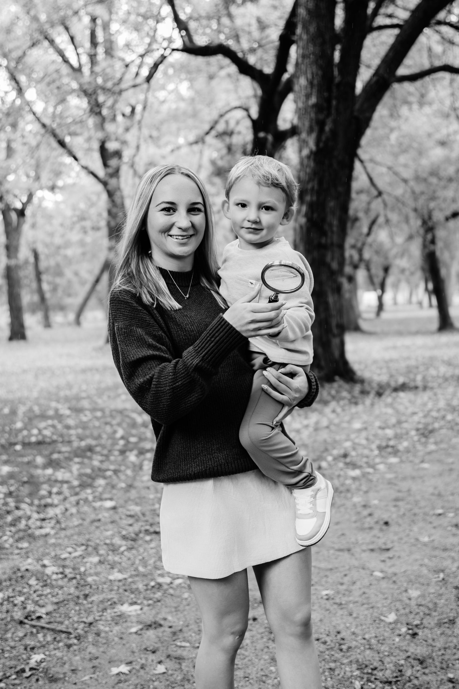 A playful outdoor photo session in a wooded area with natural lighting.