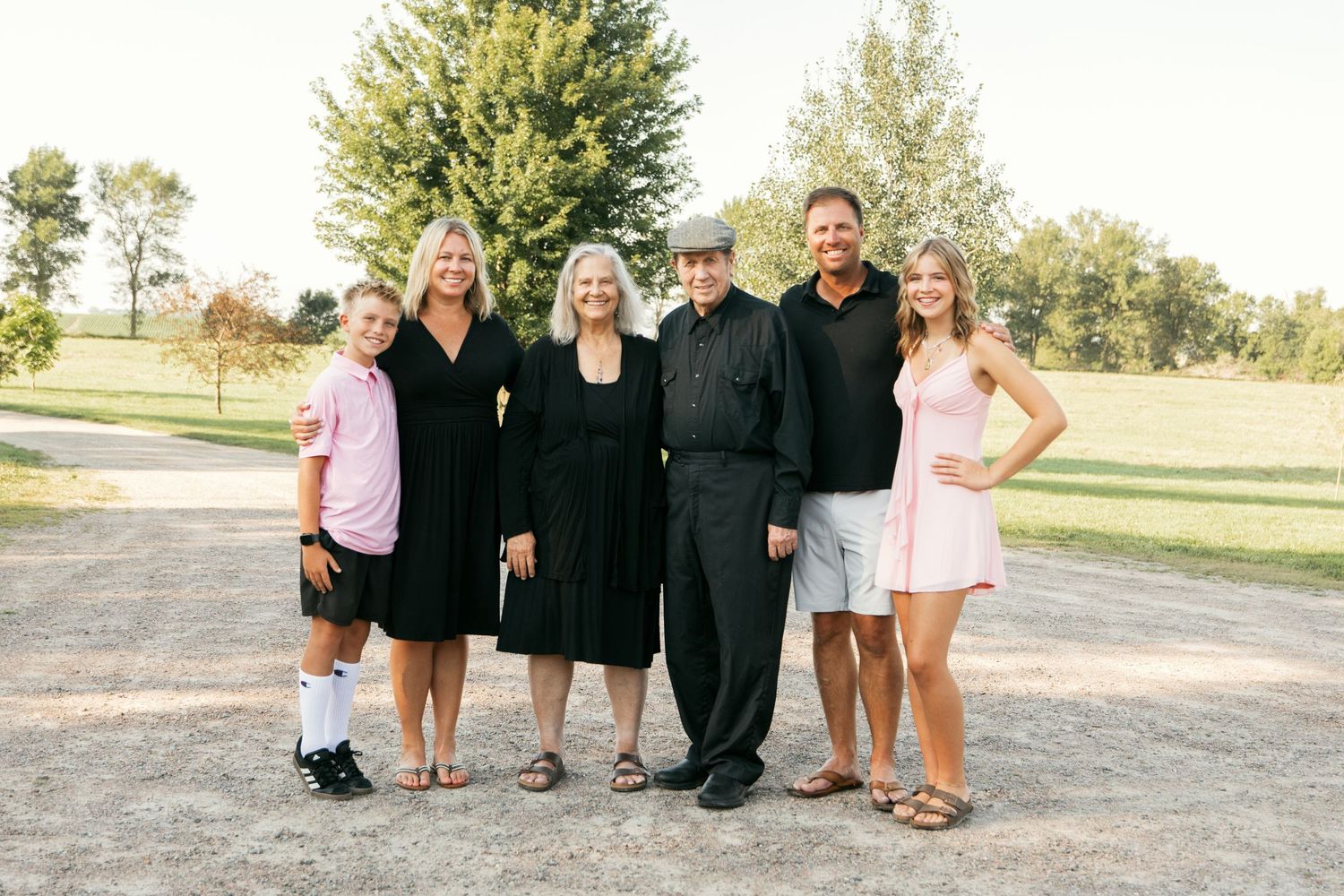 Small group portrait taken outdoors with people wearing a mix of formal and casual clothing.