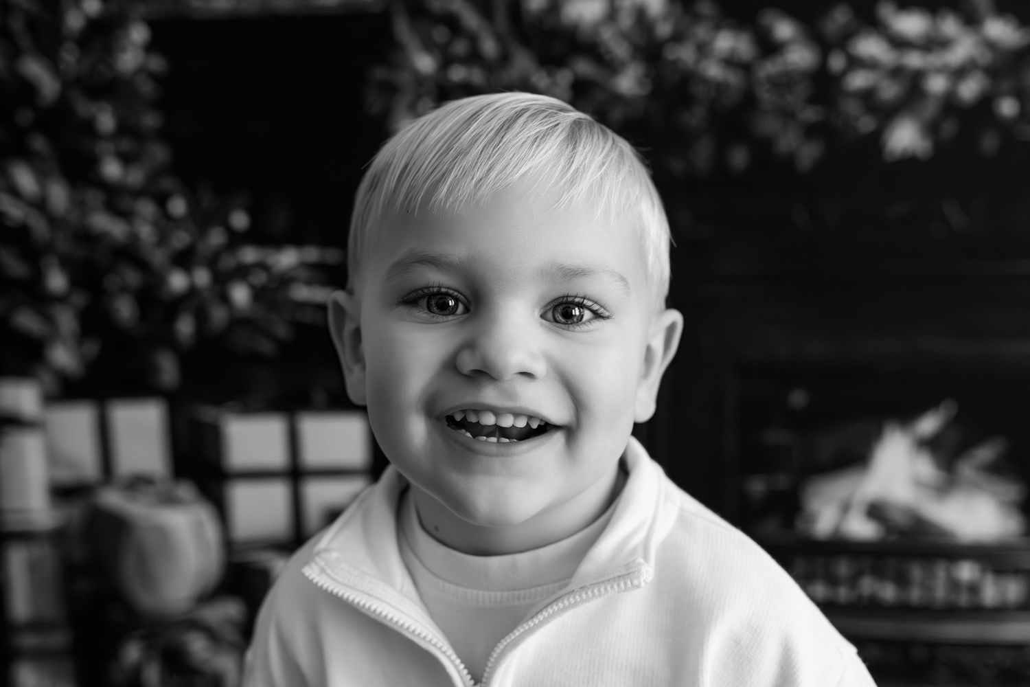 Adorable baby laughing and showing joy in black and white portrait.