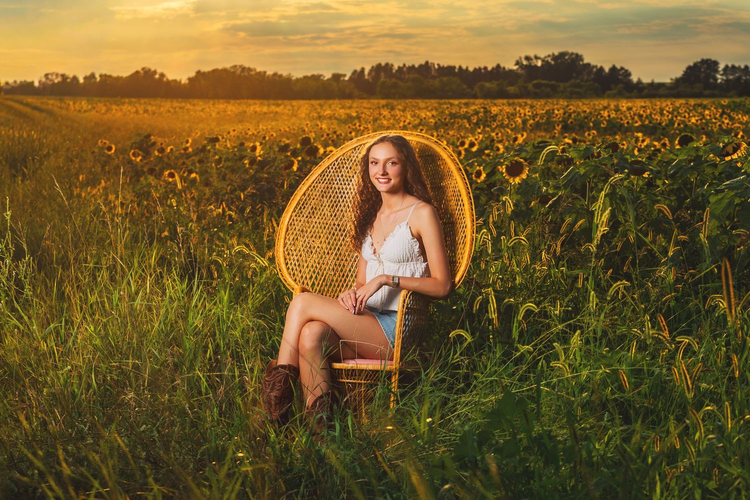 A golden sunset illuminates a field of tall sunflowers creating a warm and dreamy summer landscape.