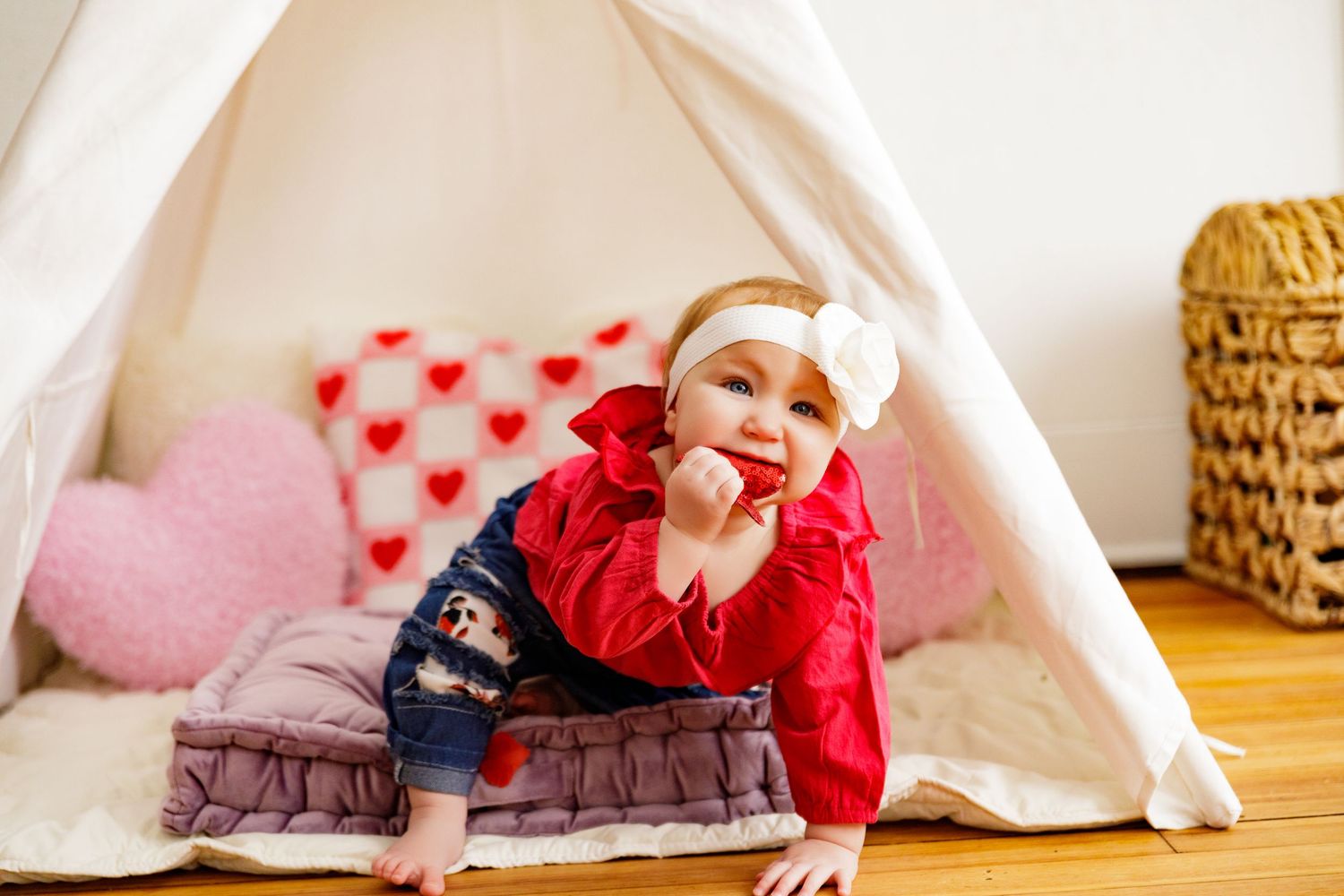 Valentine's themed photo session under a white teepee with heart decorations.