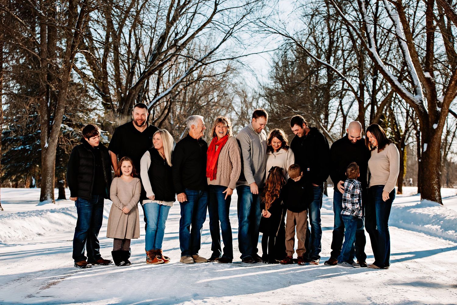 A group of people standing together in a snowy winter landscape during a photo session.