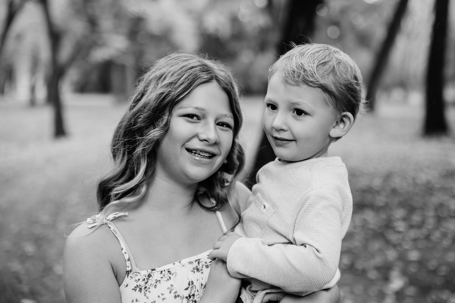 Joyful family interaction captured in black and white during outdoor session.