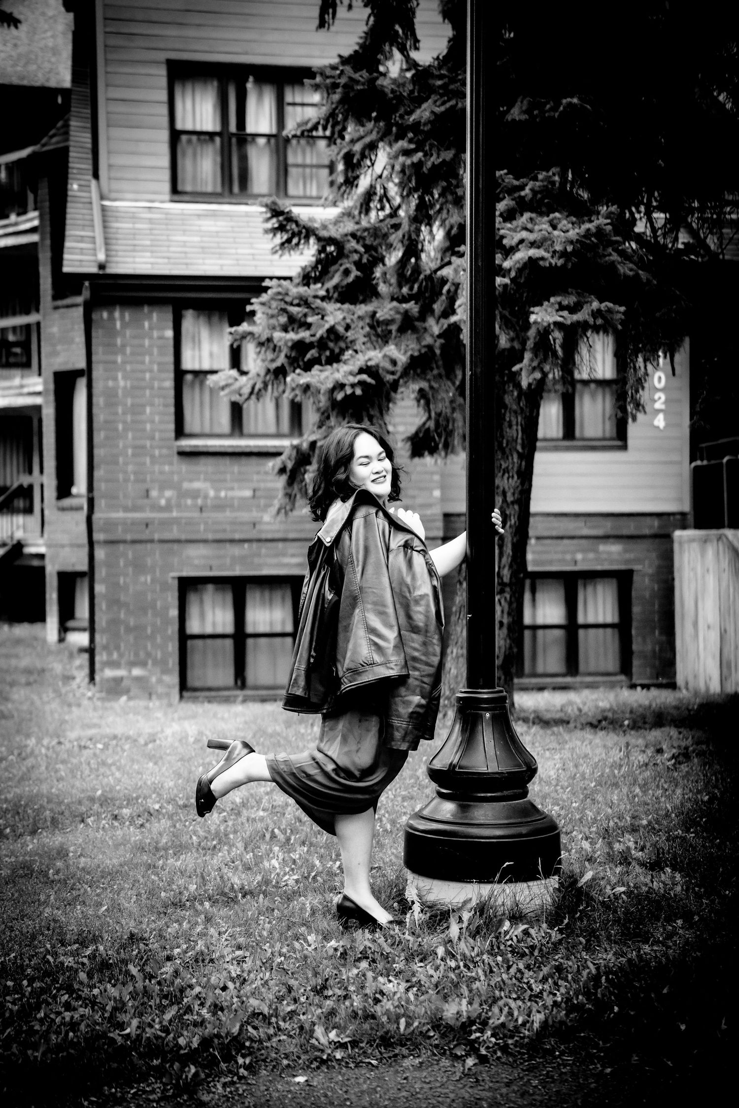 A sequence of black and white photos showing a person falling off a playground spring rider toy outside a building.