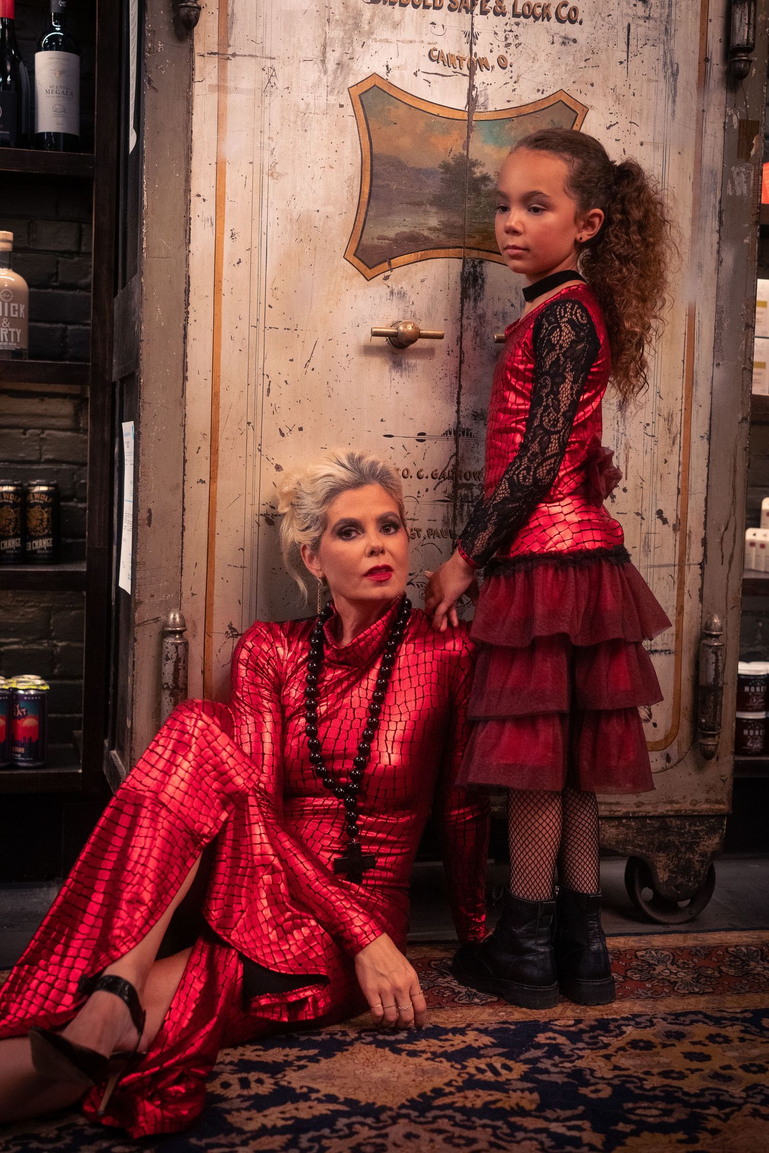 The figure strikes dramatic poses in a red silk dress against an ornate carpet in a vintage setting.