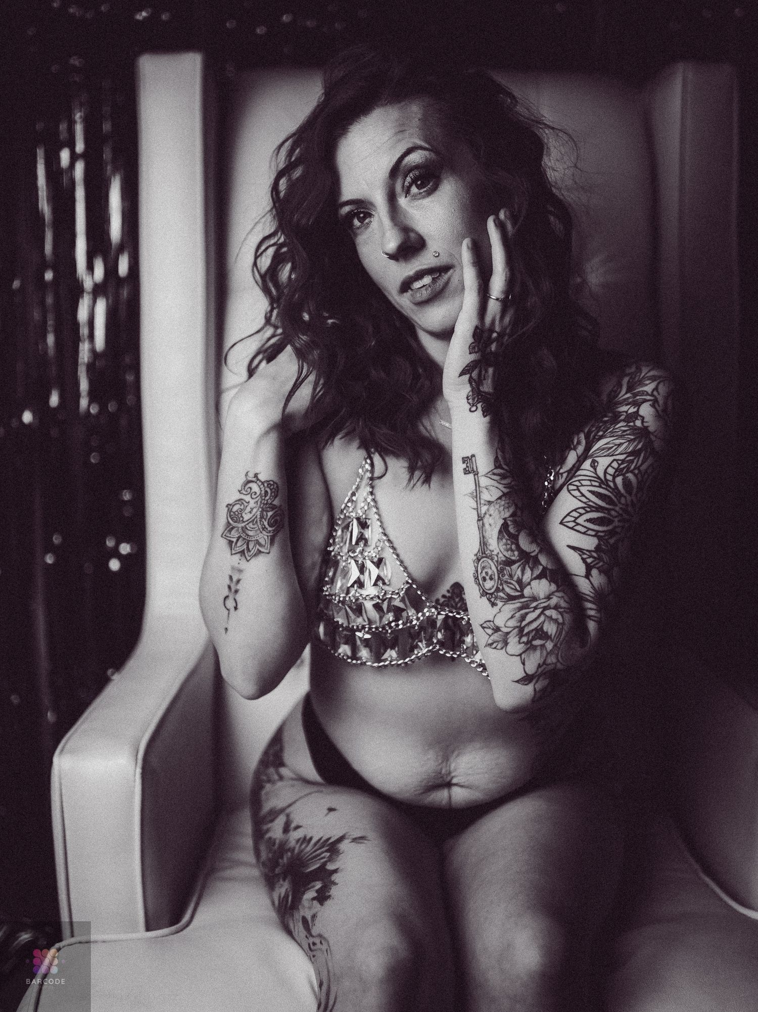 Artistic black and white boudoir photography series showing sensual poses and tattoo artwork in moody lighting.