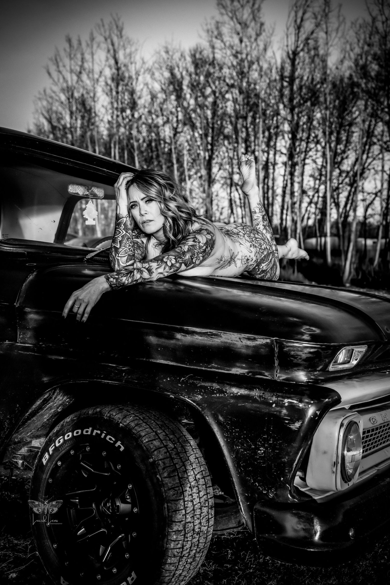 Black and white photo series showing close-up details of a vintage car's chrome trim and body panels against bare trees.