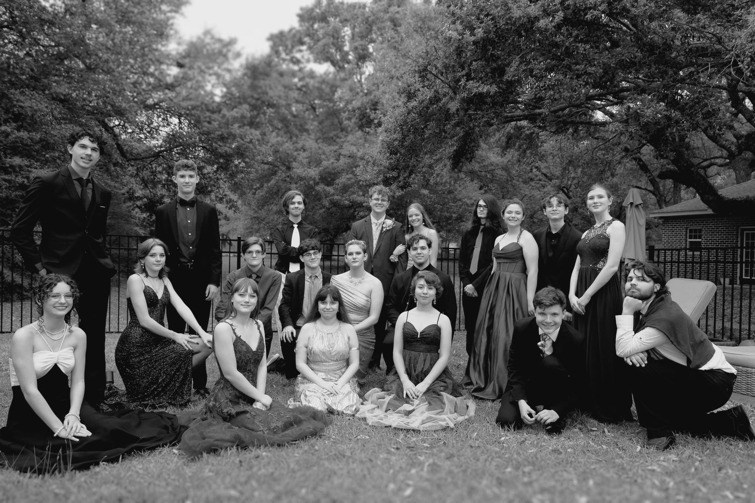 Black and white group portrait of teens in elegant formal dresses at a modern prom event—classic, timeless photography in Pace, Florida.