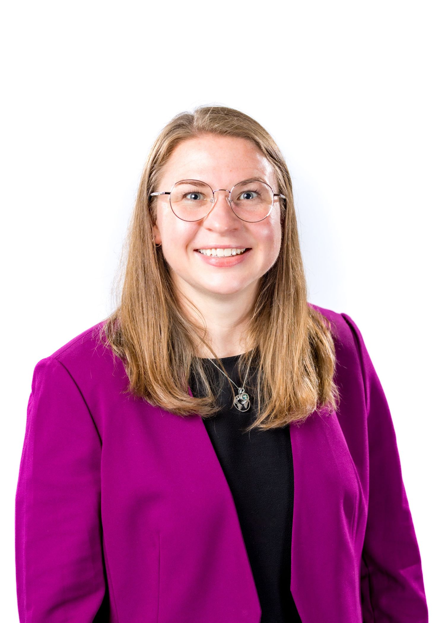 Professional woman in magenta blazer and glasses smiling confidently against white background.