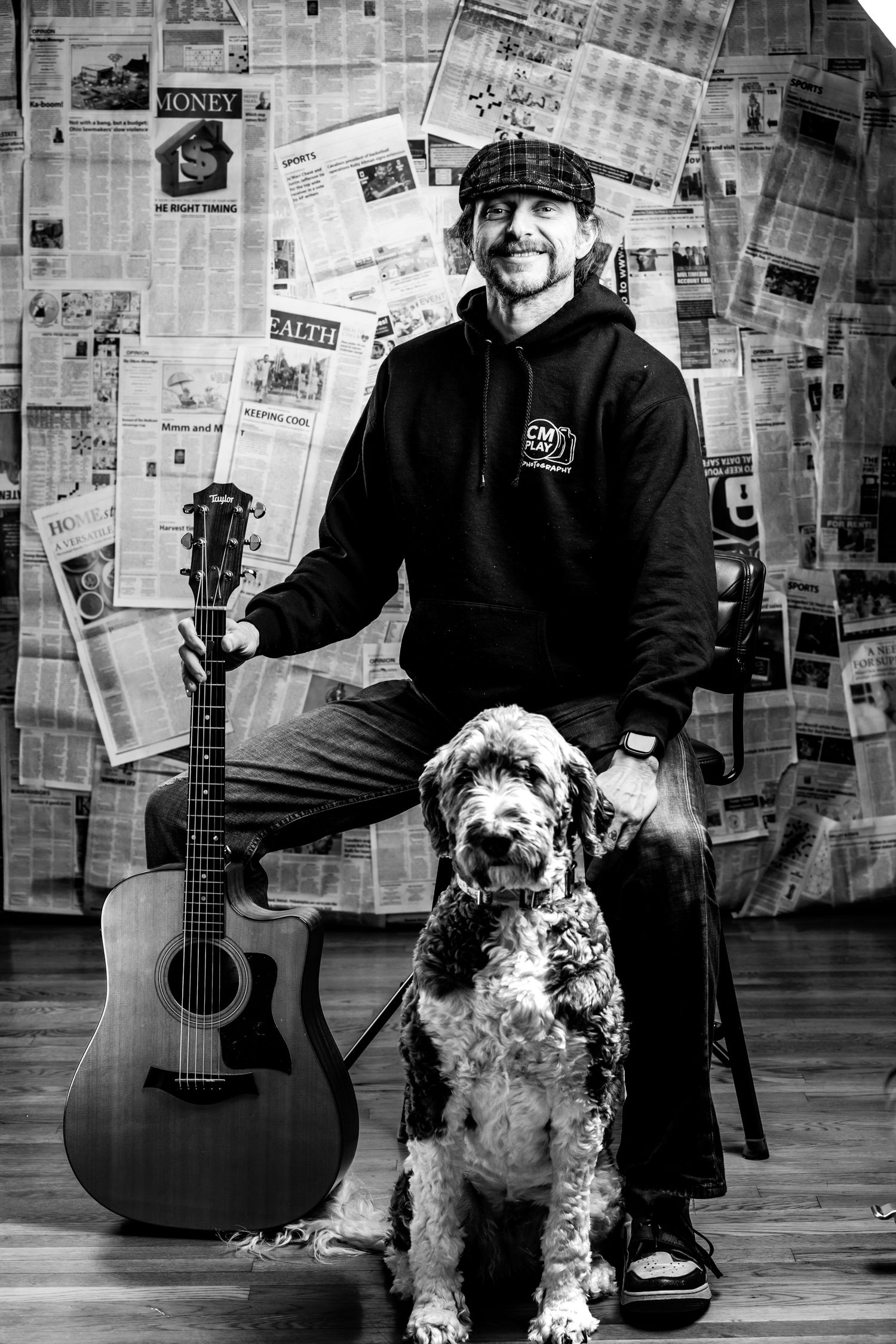 Black and white photo series showing a musician with an acoustic guitar and a spotted dog against a newspaper backdrop.