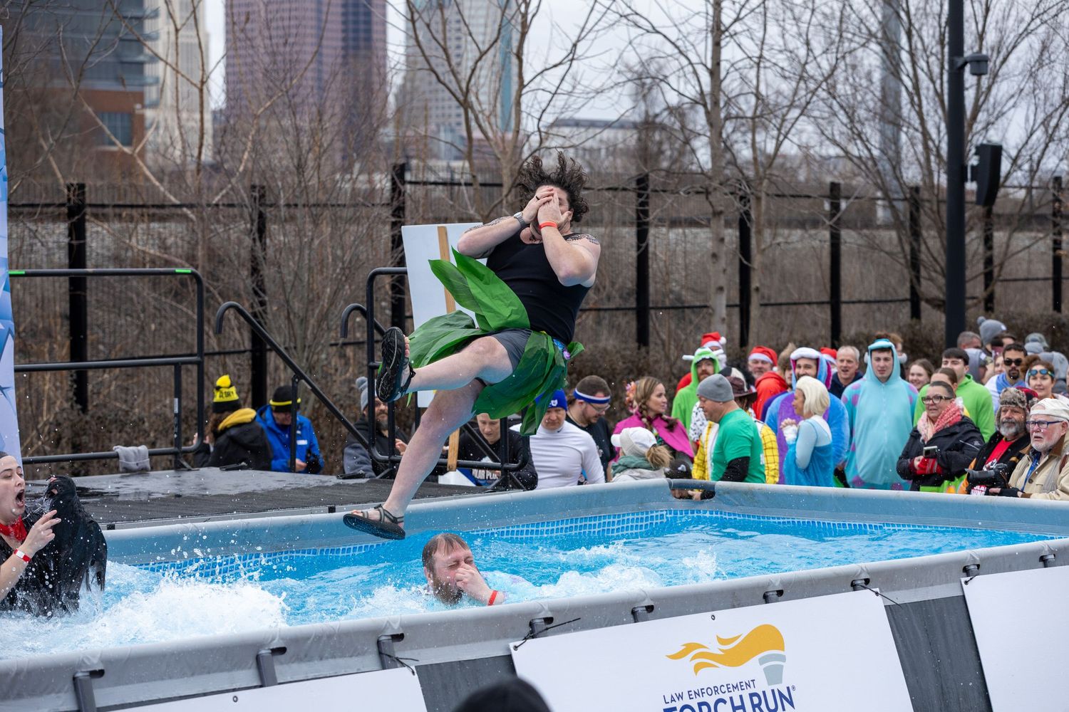A person attempts to cross a pool during a winter pond skimming event at a ski resort.