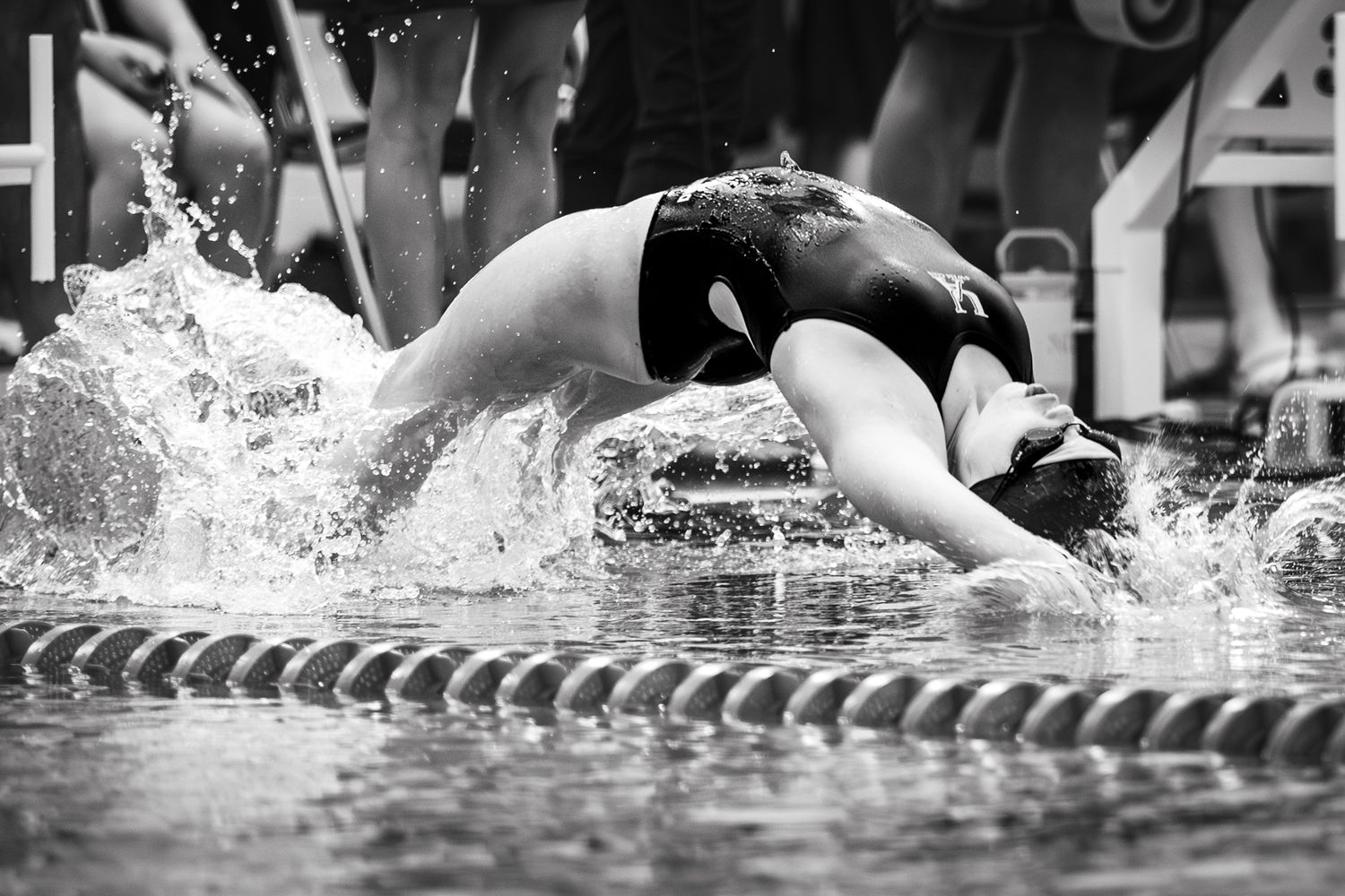 Competitive swimmers racing in a pool with splashing water during an intense swimming competition event.