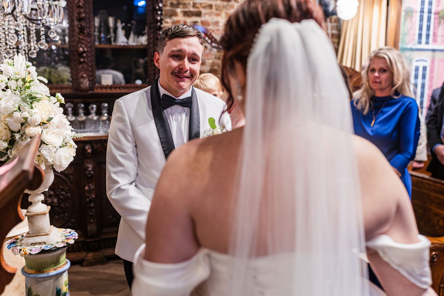 Wedding celebration inside rustic brick venue with guests dancing and mingling at reception.