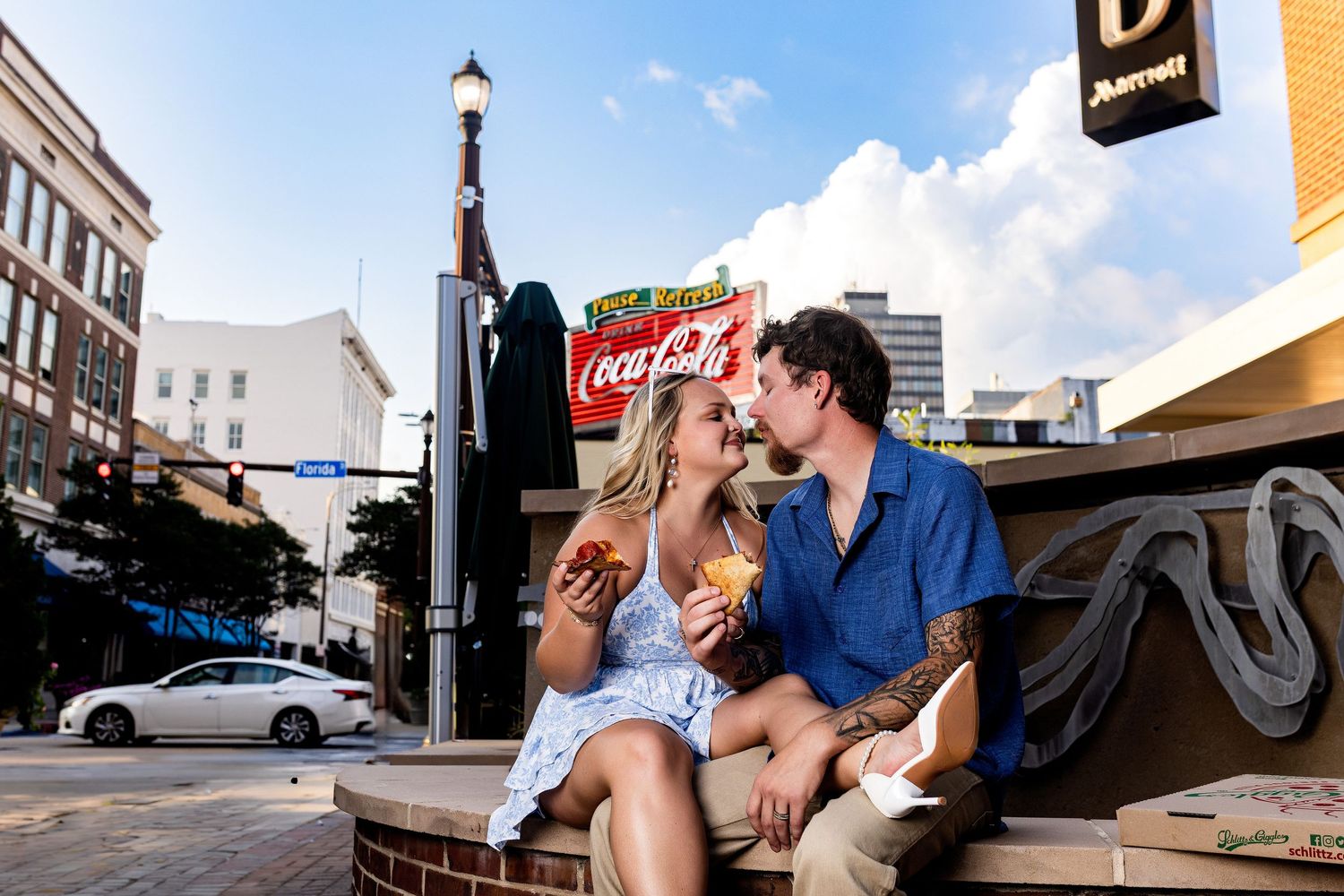 Romantic couple embraces in various urban settings including brick buildings and downtown streets.