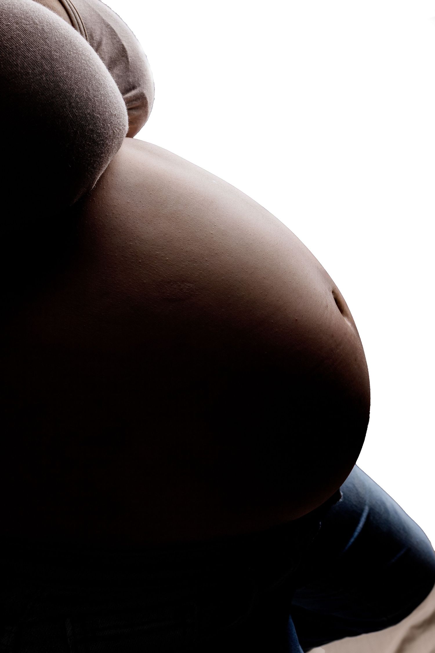 Side view silhouette progression of a pregnant woman's belly through different stages of pregnancy.