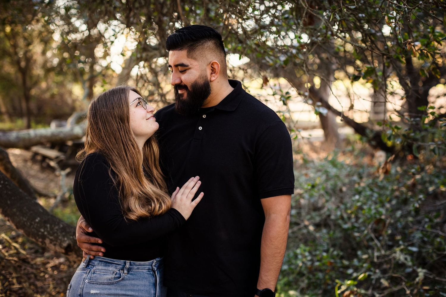 Romantic couple embraces and shares intimate moments in a sunny outdoor garden setting.