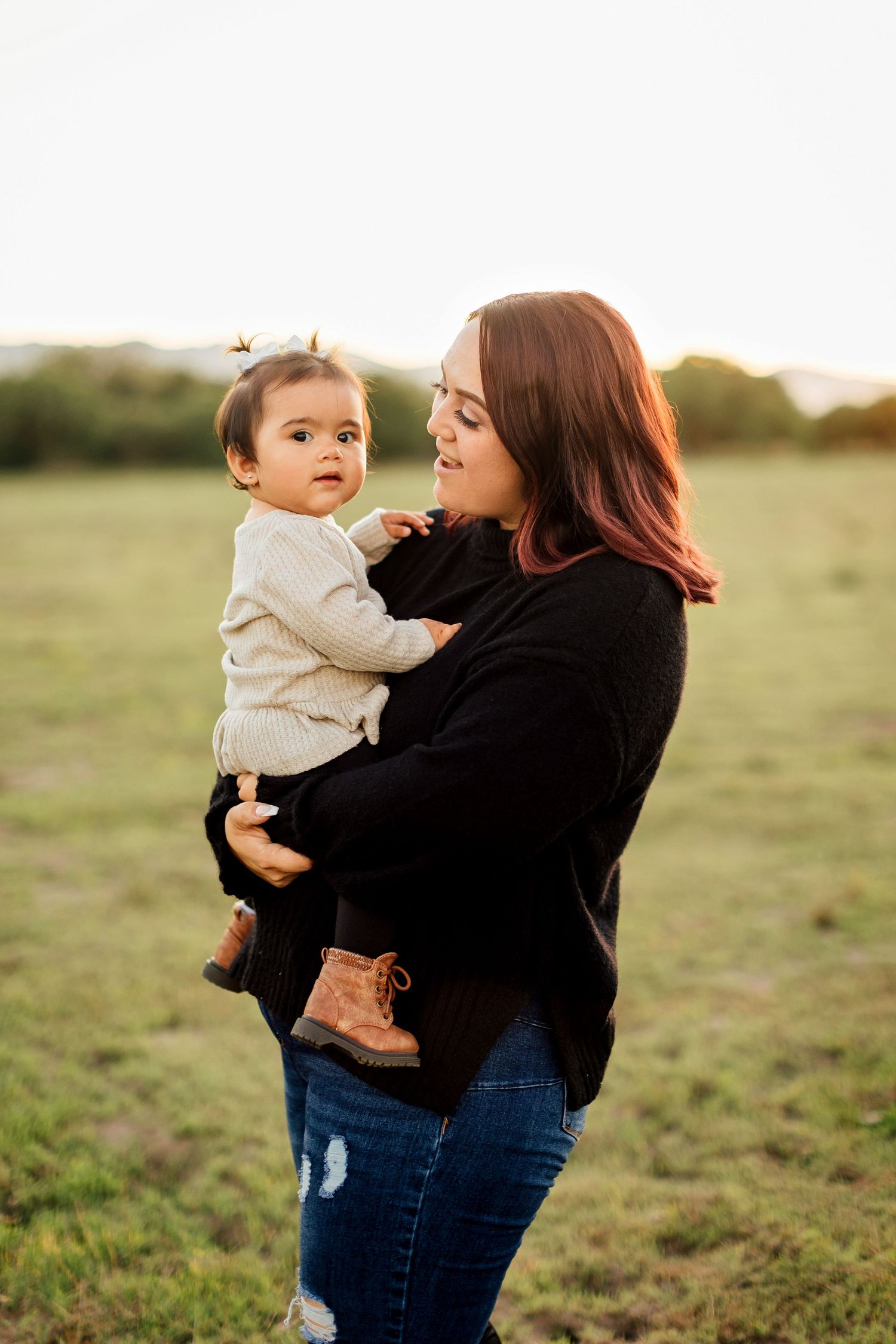Three candid portraits of a mother and child embracing in a sunlit field at golden hour.