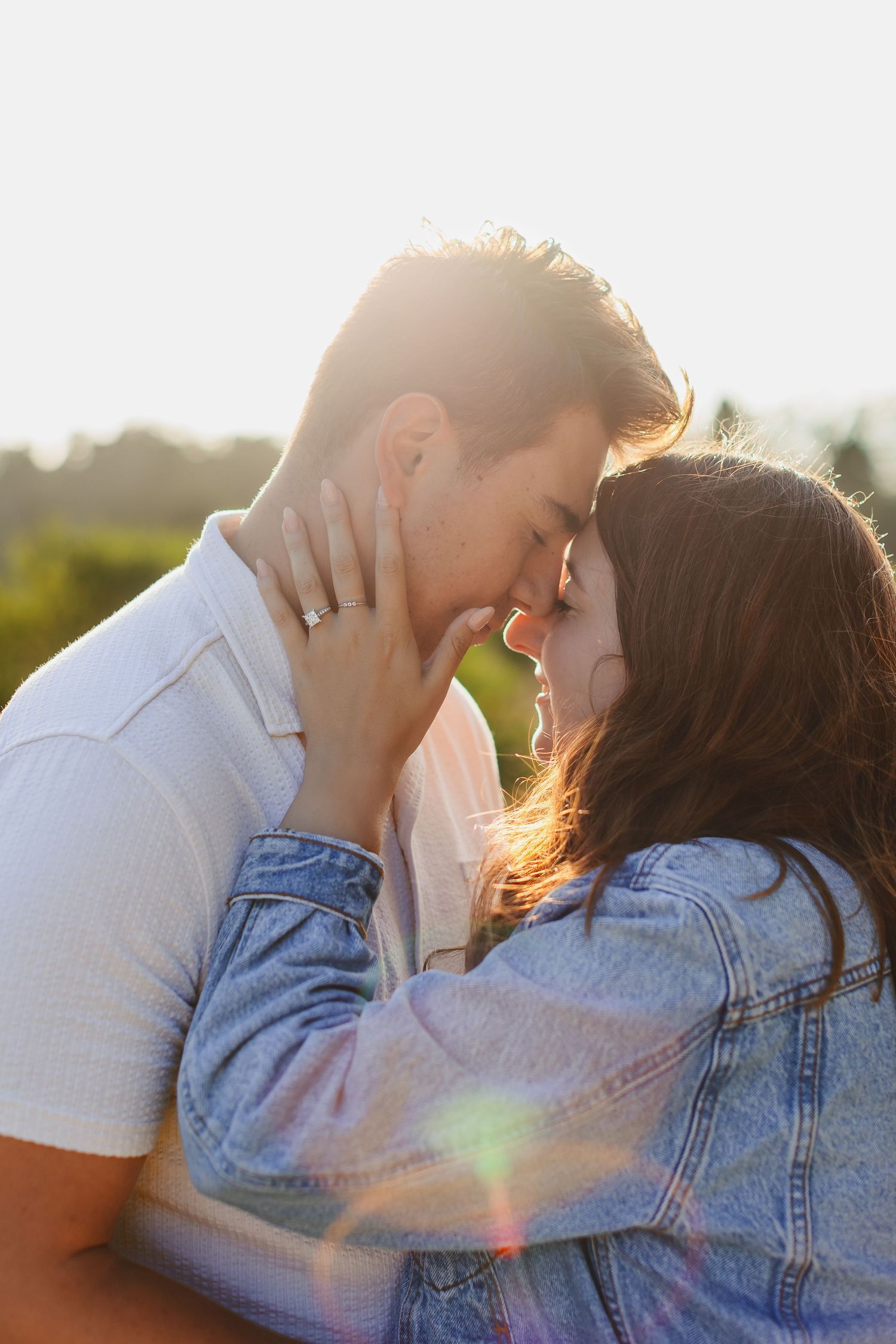 An intimate moment between a couple backlit by golden sunlight.