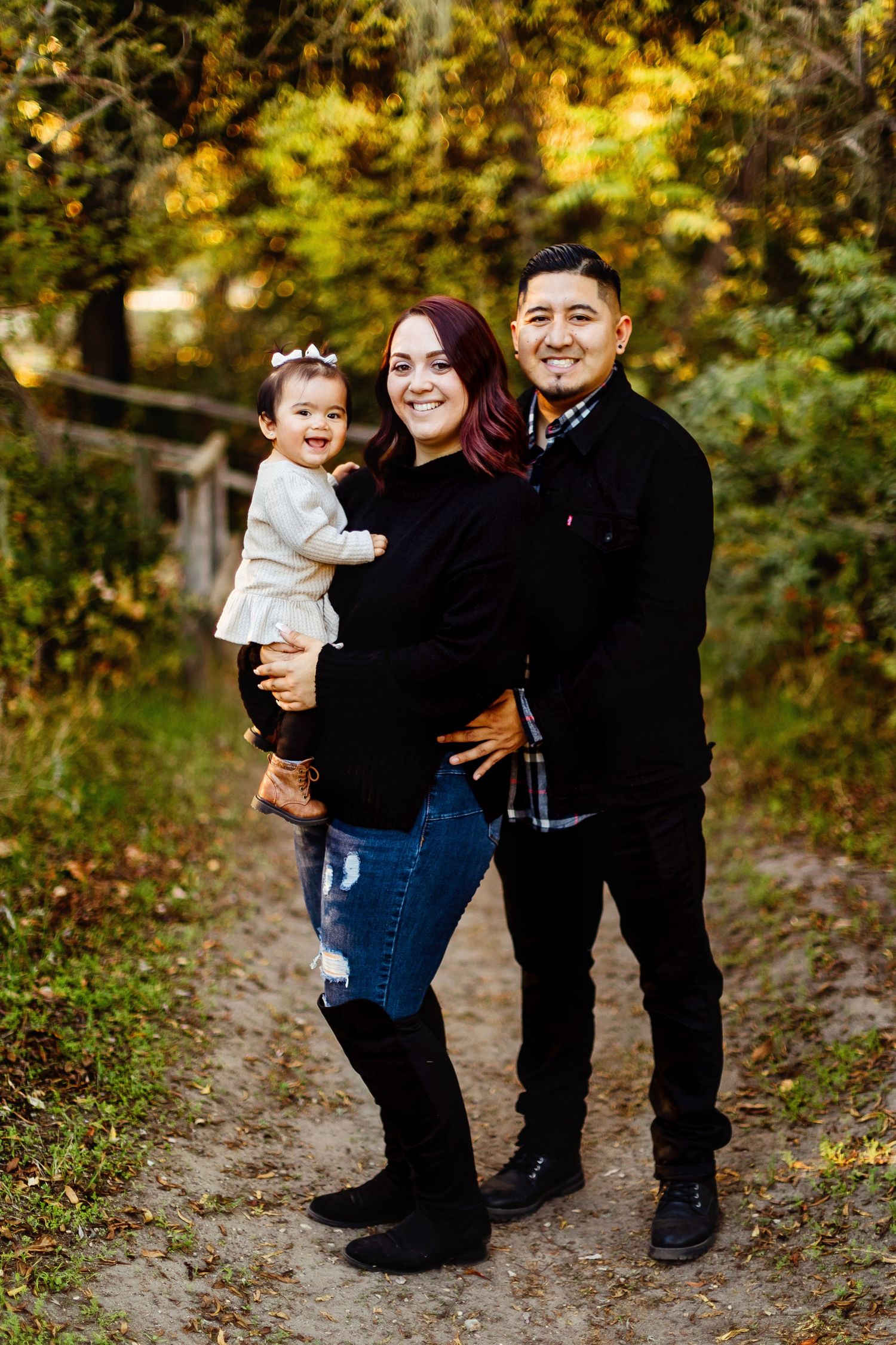 A candid photo series showing three people interacting joyfully on a leaf-covered autumn path in a wooded setting.